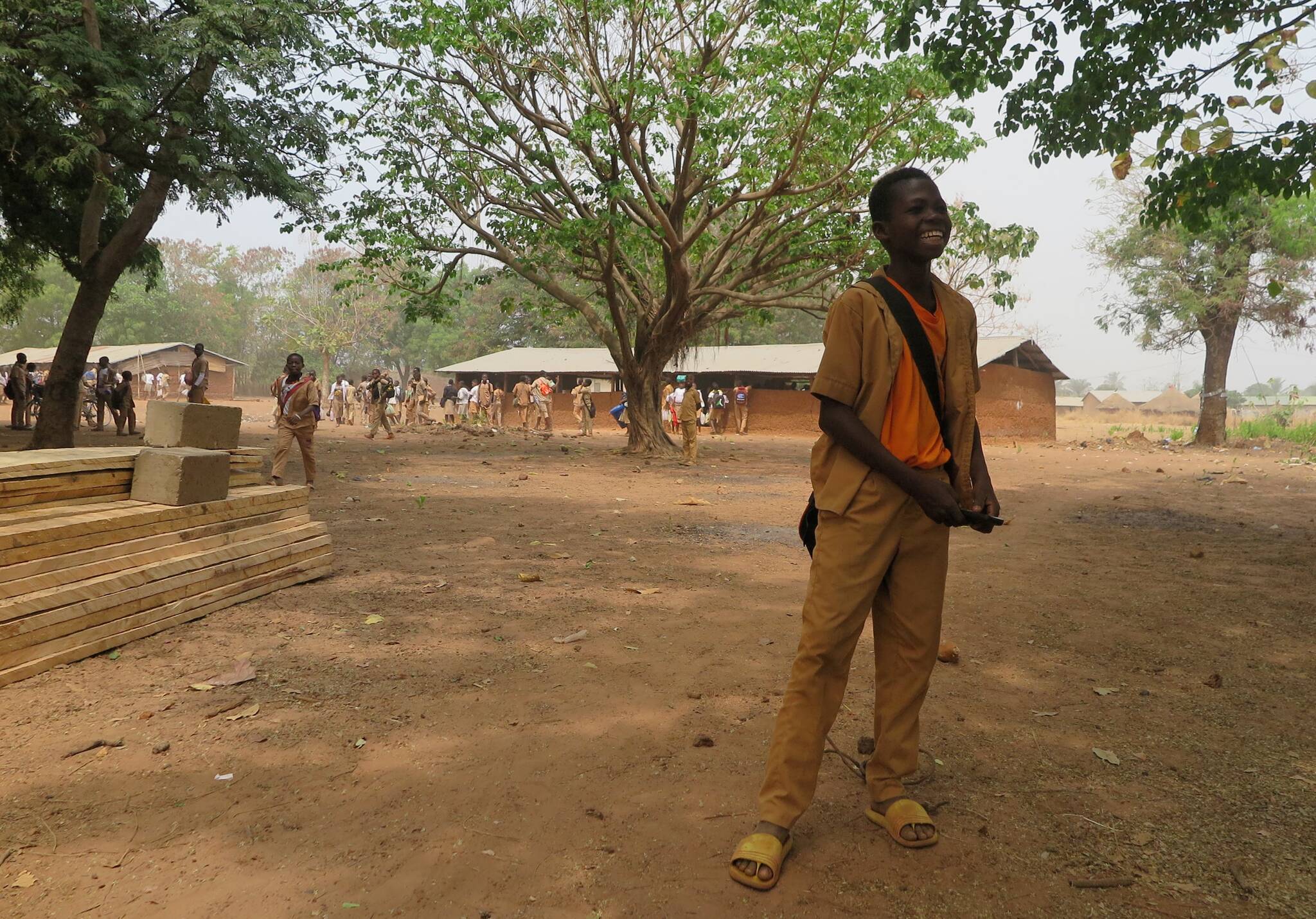 Courtesy photo / Mary McEwen 
A student stands in front of building supplies and a temporary structure as a new secondary school goes up with help from a Juneau woman who used to live in the village in Togo.