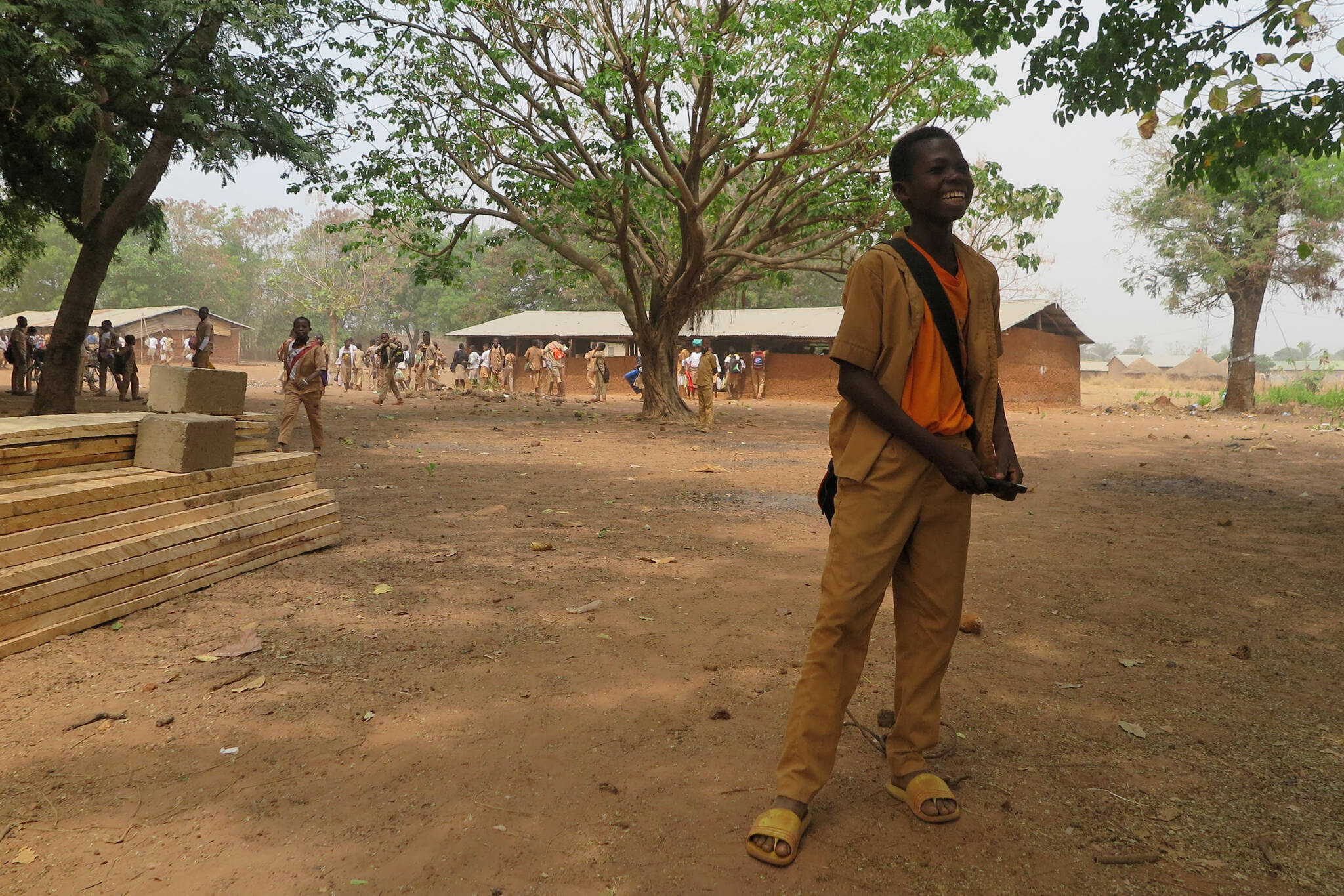 A student stands in front of building supplies and a temporary structure as a new secondary school goes up with help from a Juneau woman who used to live in the village in Togo. (Courtesy photo / Mary McEwen)