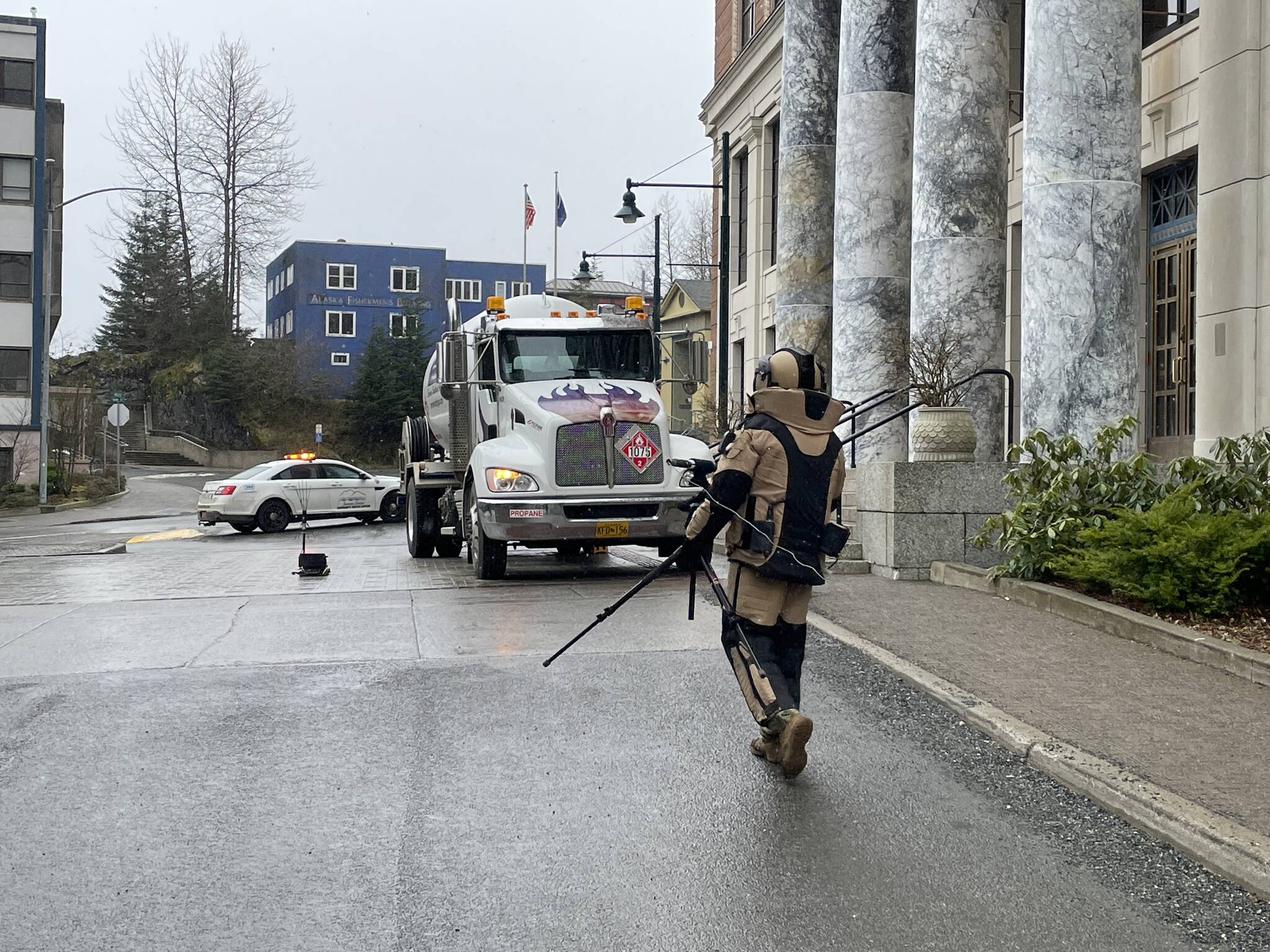 A Navy explosive ordnance disposal technician approaches a simulated vehicle-borne improvised explosive device in front of the Alaska State Capitol on March 10, 2022. (Michael S. Lockett / Juneau Empire)