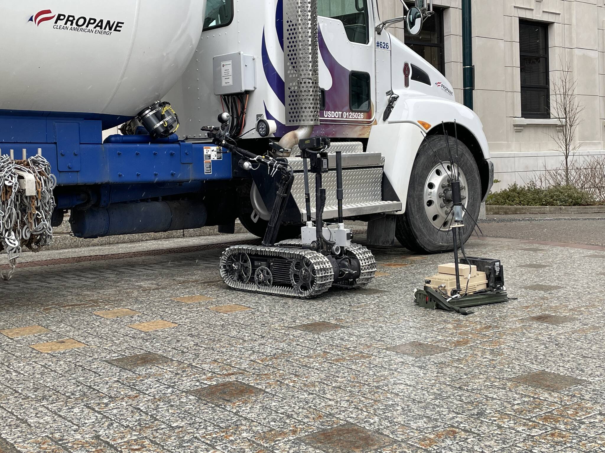 A Navy TALON robot examines a simulated vehicle-borne improvised explosive device in front of the Alaska State Capitol on March 10, 2022. (Michael S. Lockett / Juneau Empire)
