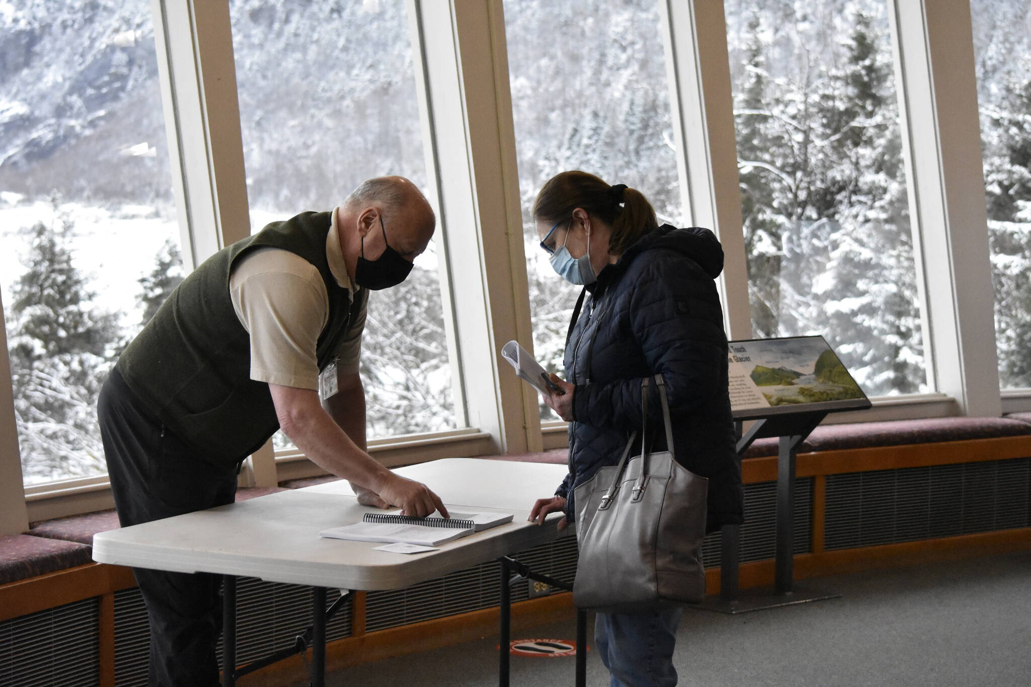 U.S. Forest Service engineer Harvey Hegett, left, explains details of the planned expansion of the Mendenhall Glacier Visitor Center at an open house at the center on Tuesday, March 15, 2022. (Peter Segall / Juneau Empire)
