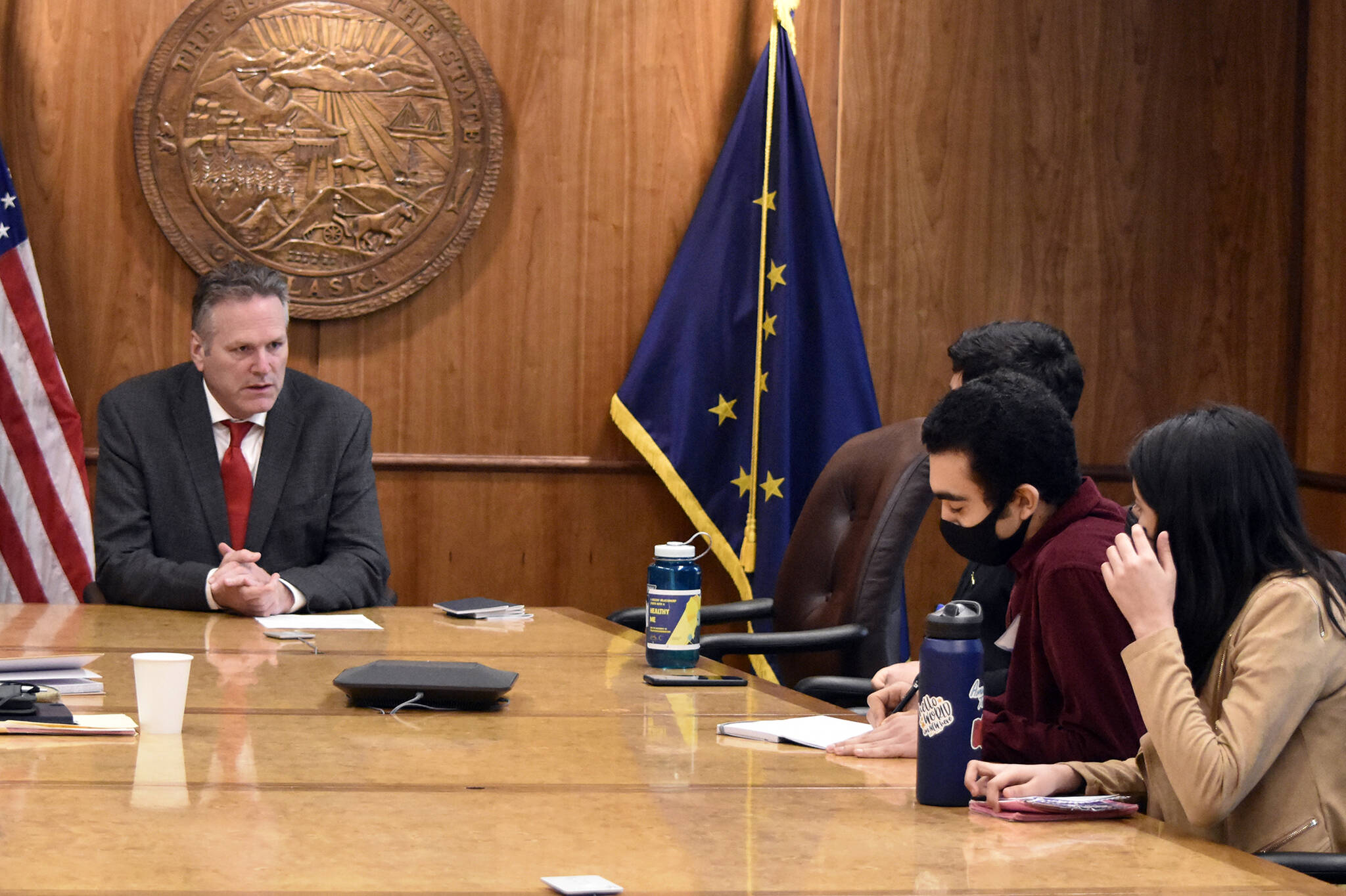 Peter Segall / Juneau Empire 
Gov. Mike Dunleavy, left, meets with international exchange students at the Alaska State Capitol on Wednesday, March 16, 2022. The students, who each come from different countries, have been living with host families in Sitka and Juneau and attending local high schools.