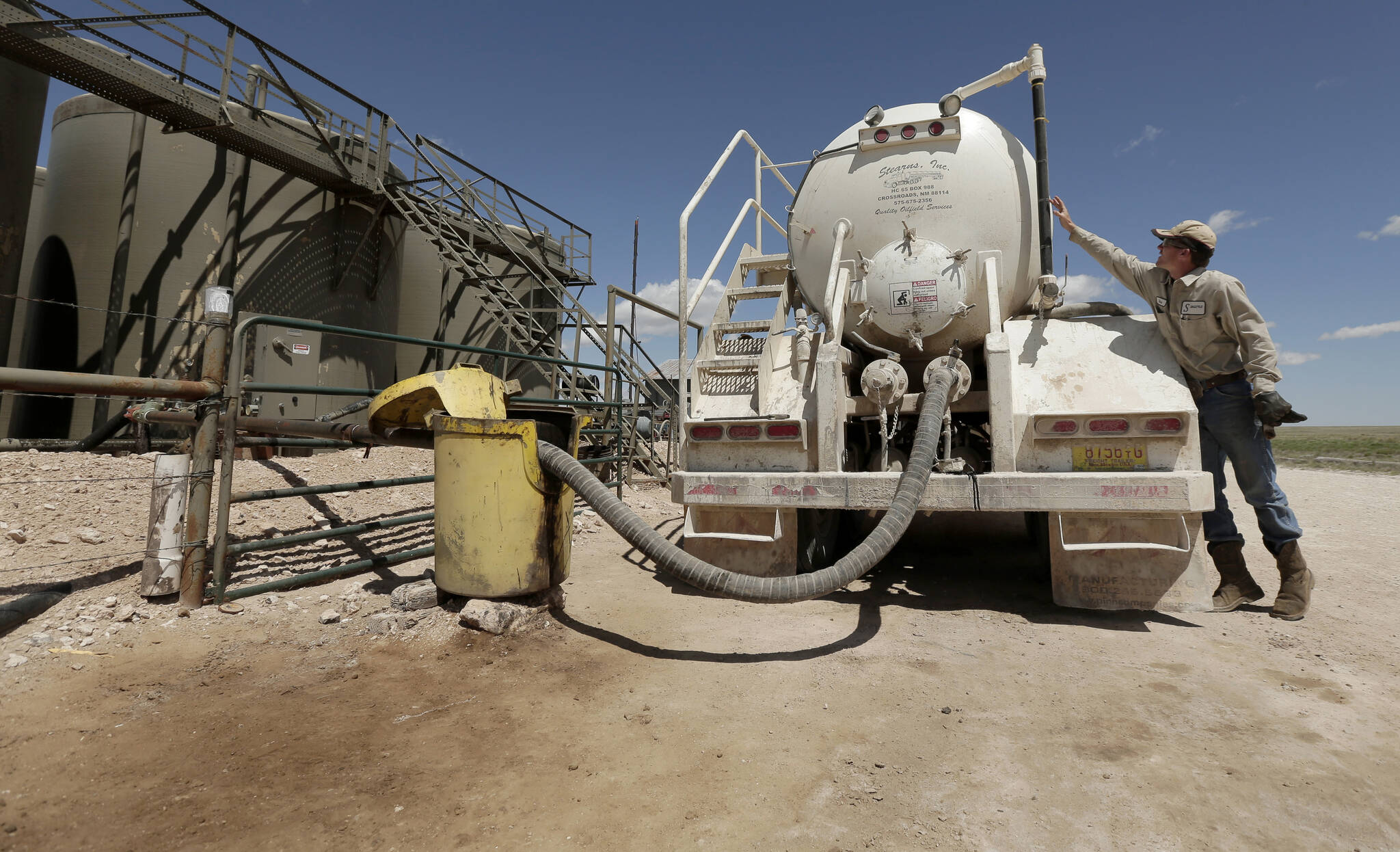 AP Photo/Charlie Riedel, File 
In this April 24, 2015, filephoto, a worker empties oilfield wastewater from a tank truck into storage tanks on Carl and Justin Johnson’s ranch near Crossroads, N.M. Labor shortages, supply problems and volatile prices have made oil companies cautious about new drilling even as U.S. politicians push for increased production.