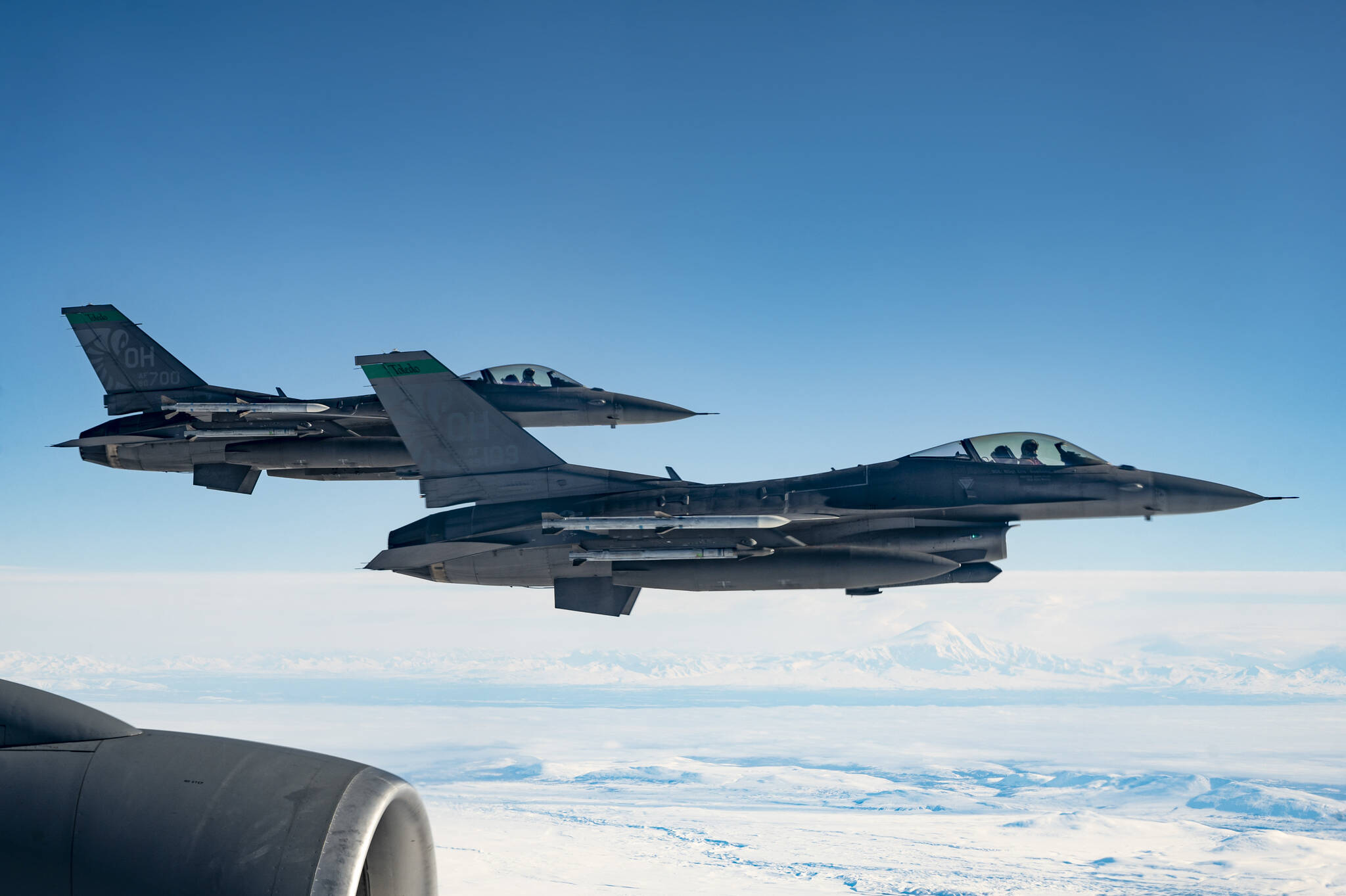 Two U.S. Air Force F-16 Fighting Falcons, assigned to the 180th Fighter Wing, fly in formation after being refueled by a KC-135 Stratotanker, assigned to the 97th Air Refueling Squadron, during U.S. Northern Command Exercise Arctic Edge 2022, March 15, 2022. (U.S. Air Force / Staff Sgt. Taylor Crul)