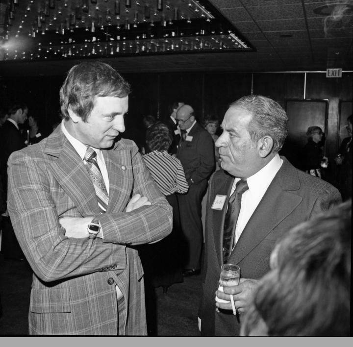 Rep. Don Young (left) stands with Jesse Carr (right)in hotel banquet room during a birthday party for Ted Steven in this November 1975 photo. (Alaska Digital Archives, Anchorage Museum at Rasmuson Center Steve McCutcheon Collection)