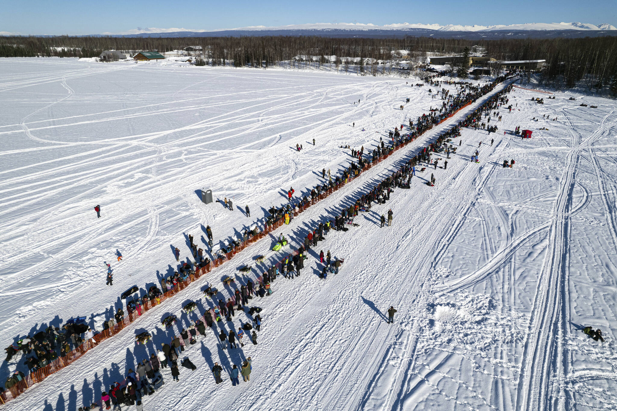 A competitor mushes across Willow Lake during the restart of the Iditarod Trail Sled Dog Race on March 6, 2022, in Willow, Alaska. Two back-of-the-pack mushers had to be rescued in separate incidents from race Friday, March 18, after winds from a severe ground storm caused deteriorating conditions, race officials said. (Loren Holmes / Anchorage Daily News)