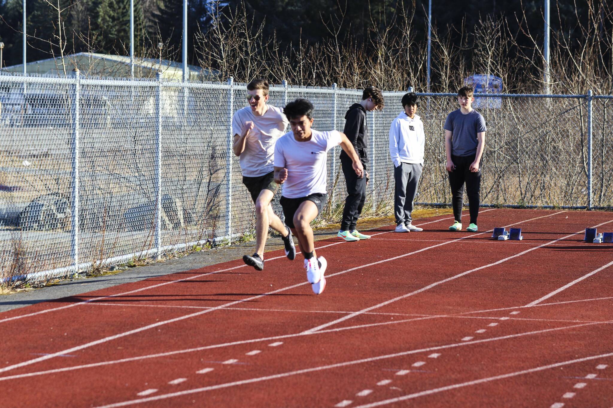TMHS runners Audimyre Horca (front) and Elijah Goins practice starts off the blocks on April 14, 2022. (Michael S. Lockett / Juneau Empire)