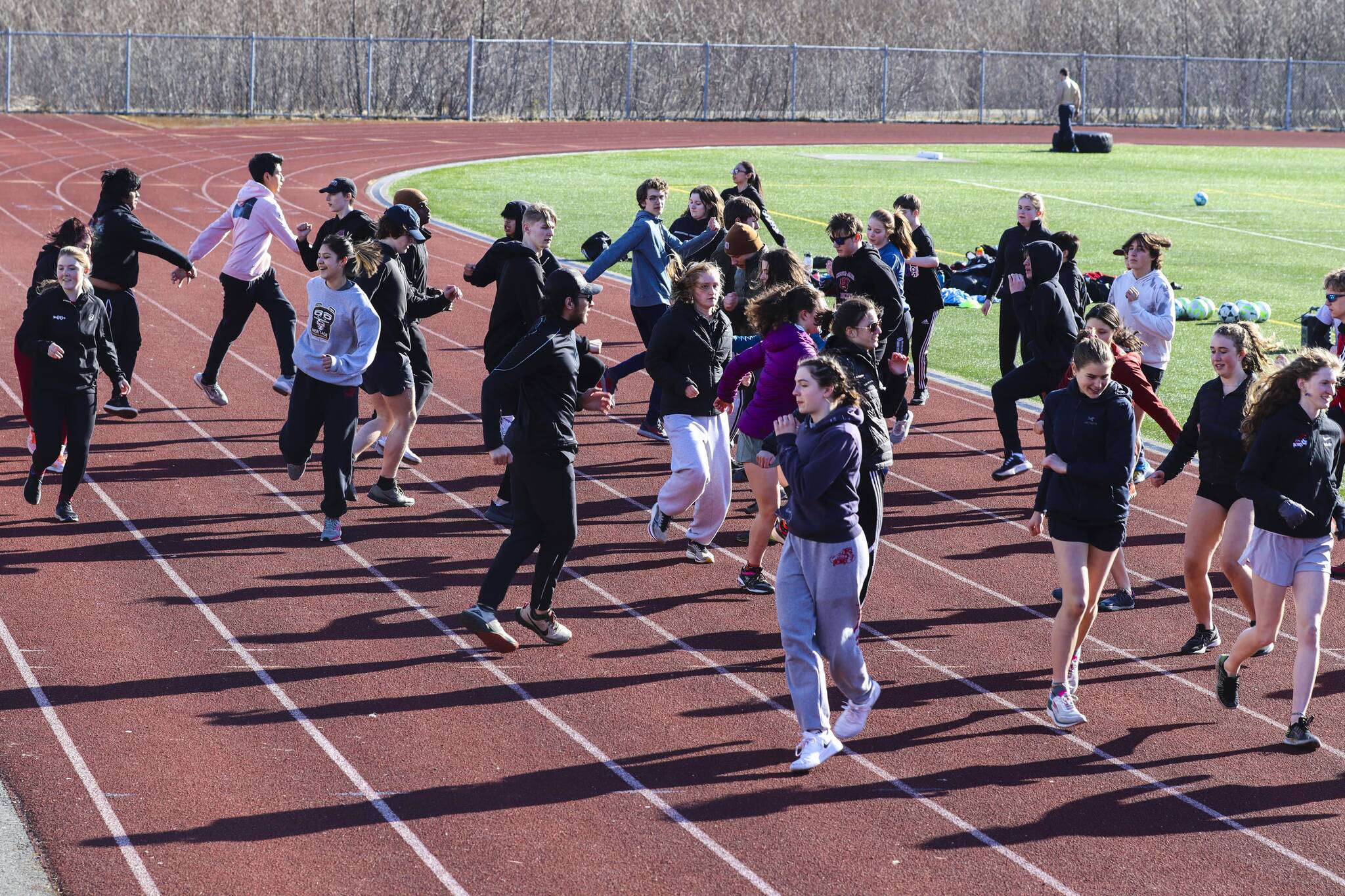The JDHS track and field team does a warm-up exercise during practice at TMHS on April 14, 2022. (Michael S. Lockett / Juneau Empire)