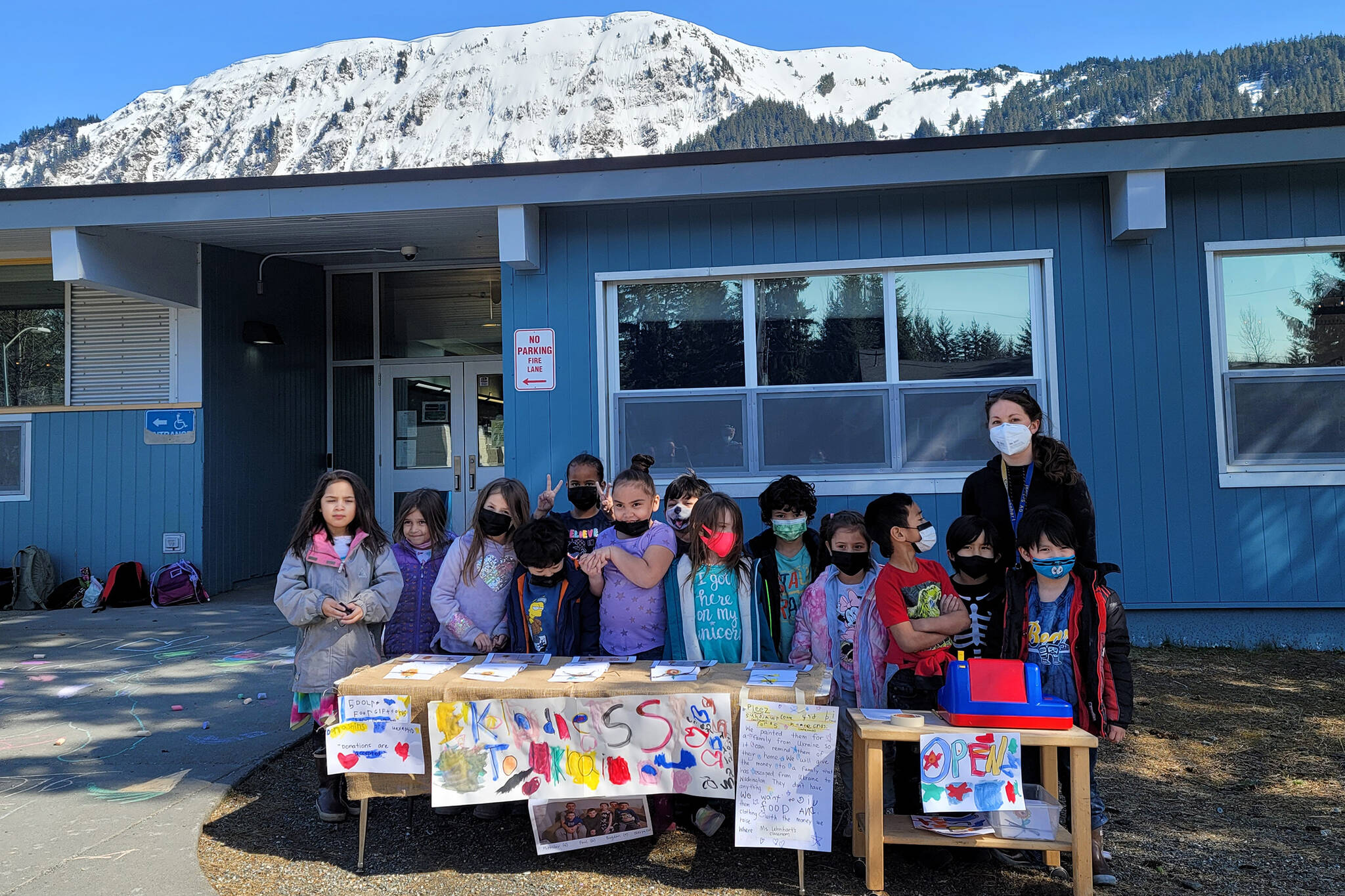 Ben Hohenstatt / Juneau Empire 
Students in Carly Lehnhart’s kindergarten class stand near a card stand outside Sít<em>ʼ</em> Eetí Shaanáx̱ - Glacier Valley School. The students sold cards on Friday to raise money to support a Ukrainian family living in Washington state.