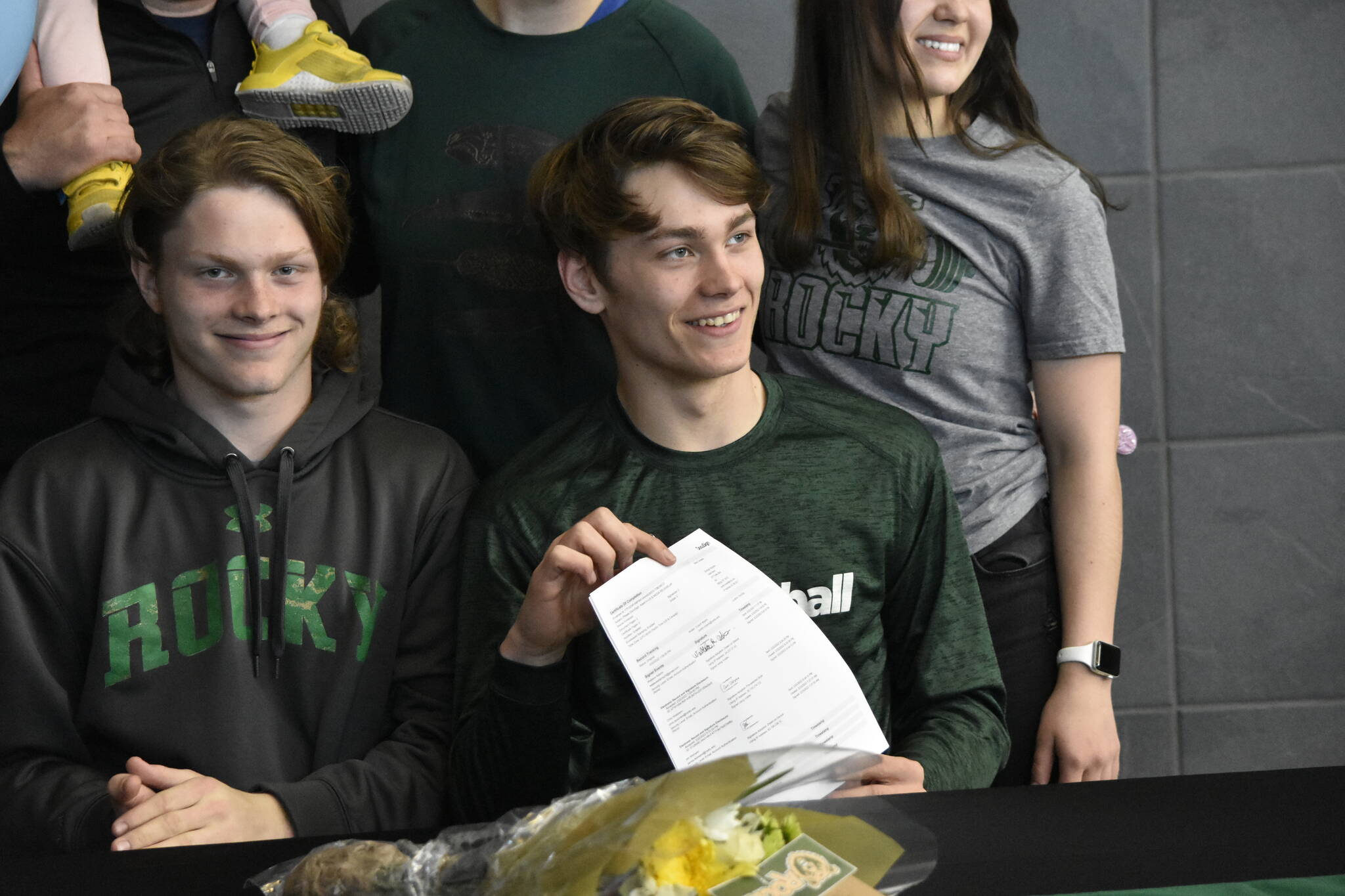 Wallace Adams, center, with his brother Owen, holds up an agreement to play football at Rocky Mountain College in Billings, Montana, during a signing ceremony at Thunder Mountain High School on Wednesday. Adams told the Empire he was grateful to his parents for their support. “They’ve always supported me in everything I’ve done.”