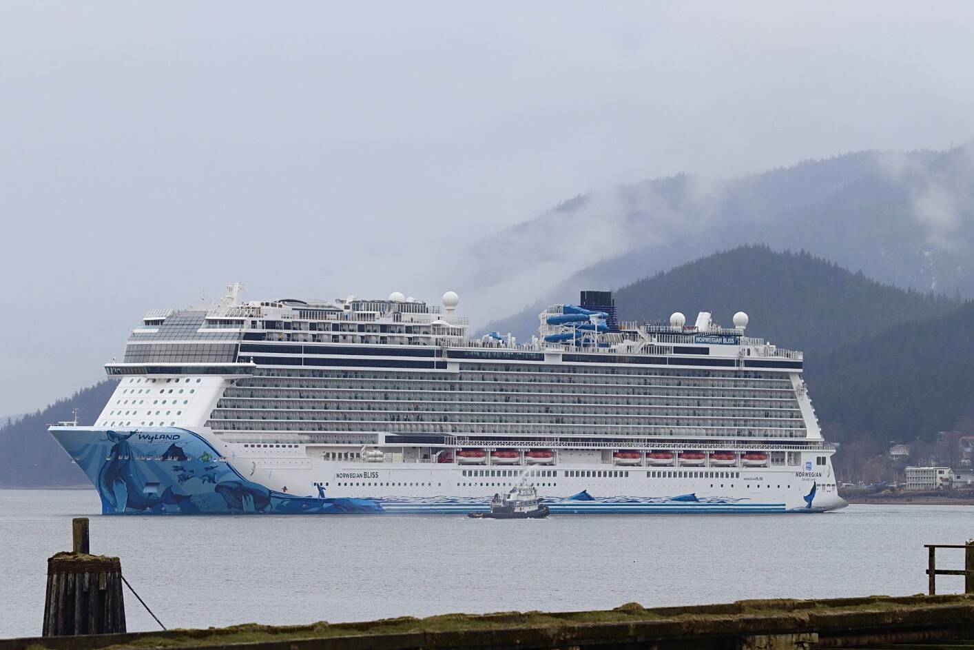 A tugboat sprays its water cannons in welcome as the Norwegian Bliss arrives in Juneau on April 25, 2022, the first cruise of the 2022 season. (Michael S. Lockett / Juneau Empire)