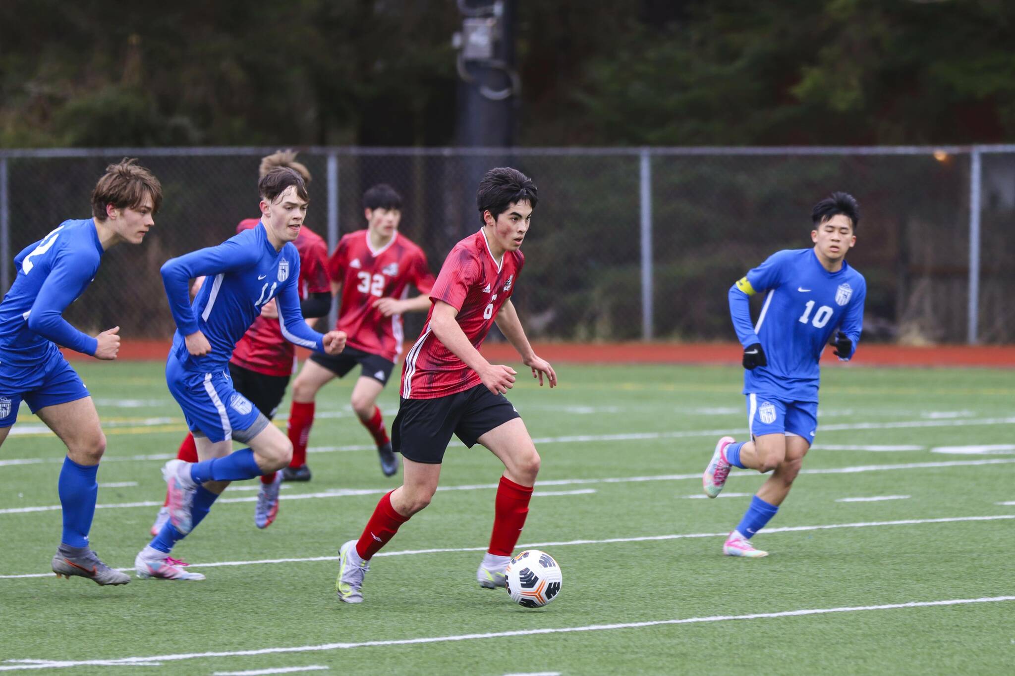 JDHS player Gabe Cheng drives down the field with the ball during a tight game against TMHS on April 23, 2022. (Michael S. Lockett / Juneau Empire)