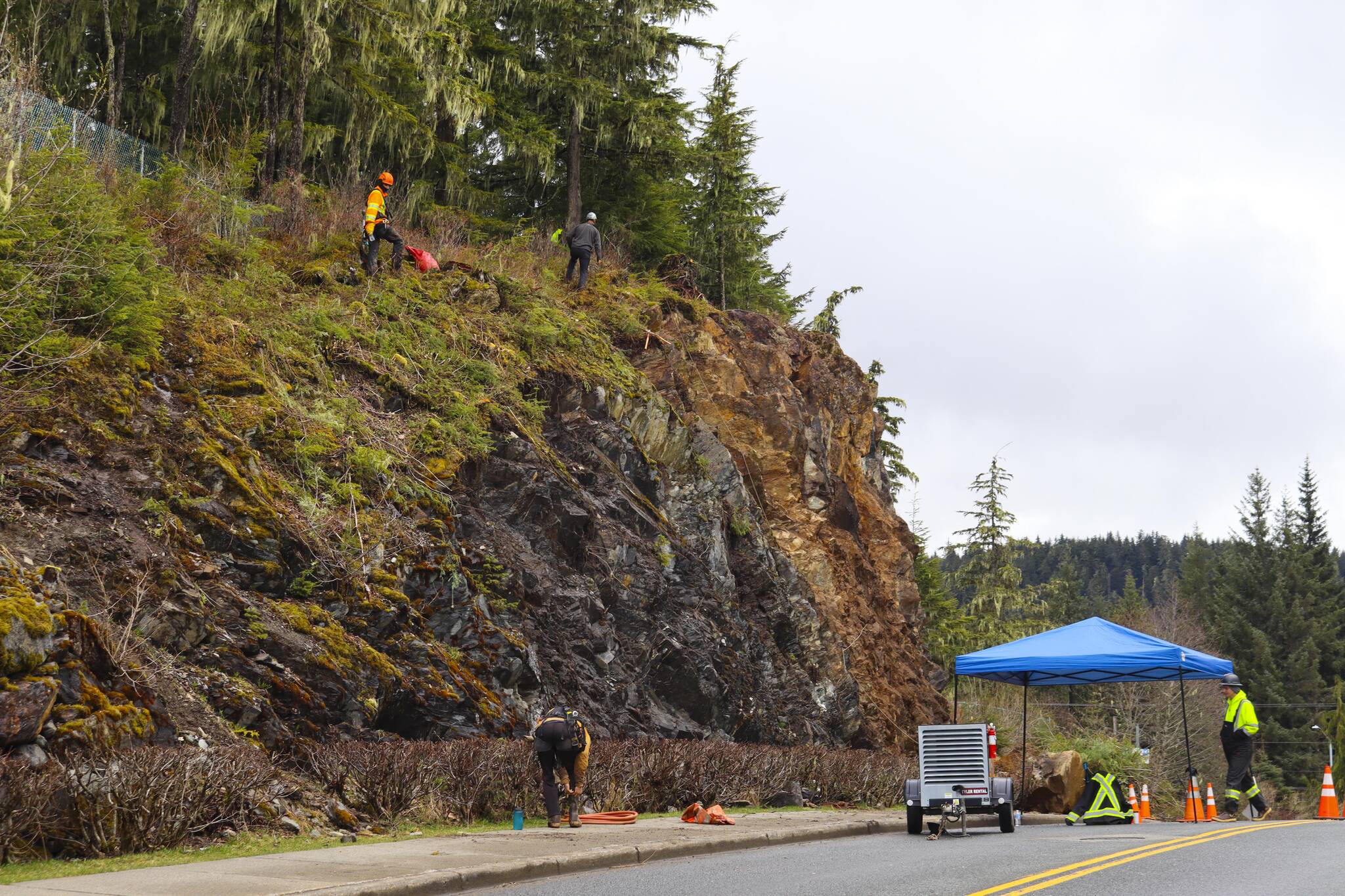 University of Alaska Southeast employed contractors from Advanced Blasting Services to clear remaining material from a cliffside that had a substantial rockslide in February. (Michael S. Lockett / Juneau Empire)