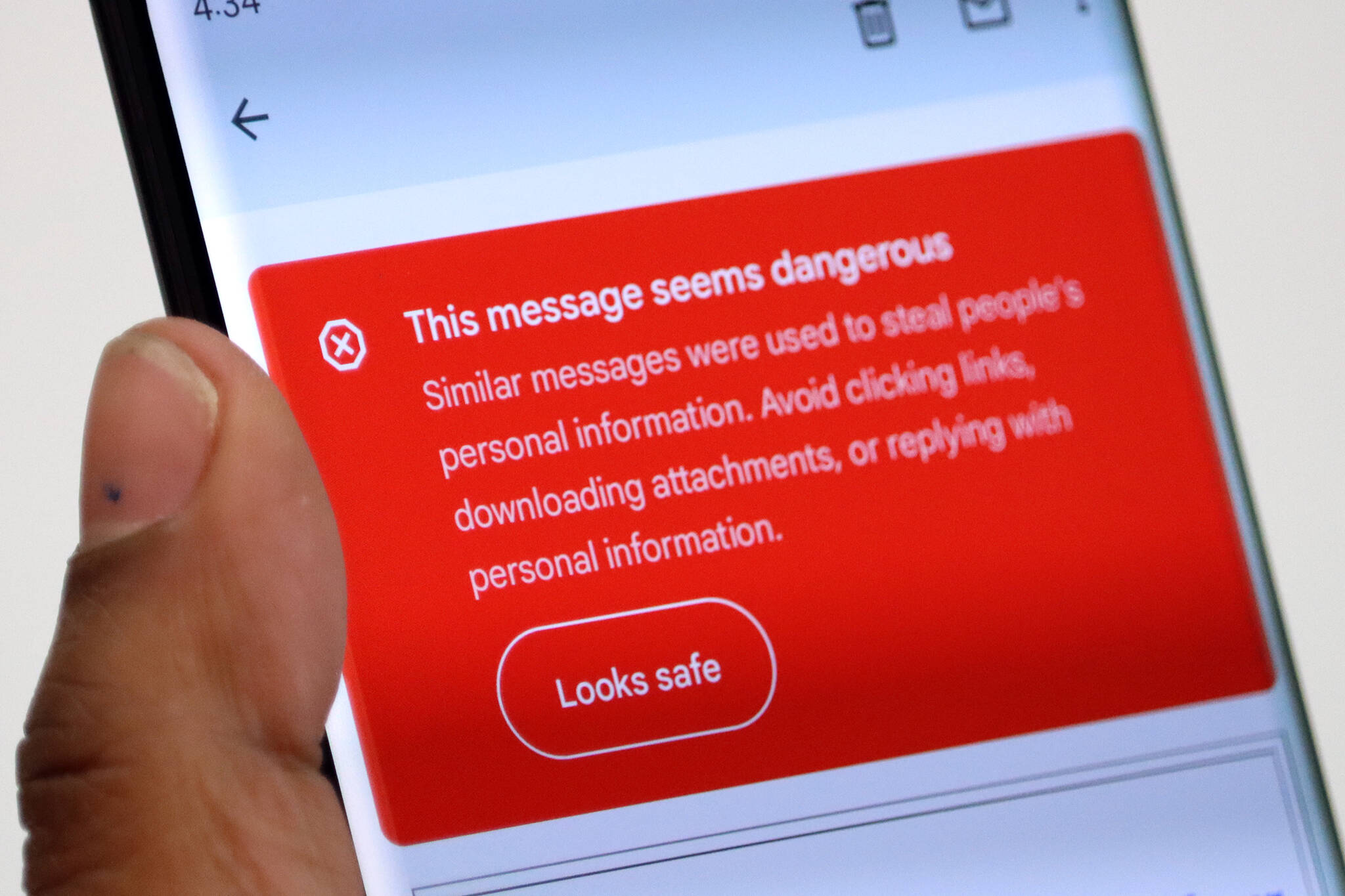 A phone screen displays a message warning that a suspicious email may be an attempt at stealing personal information. Cybercrime rose to new heights in 2021, according to FBI data, but there are some steps people can take to be safe, according to local law enforcement. (Ben Hohenstatt / Juneau Empire)