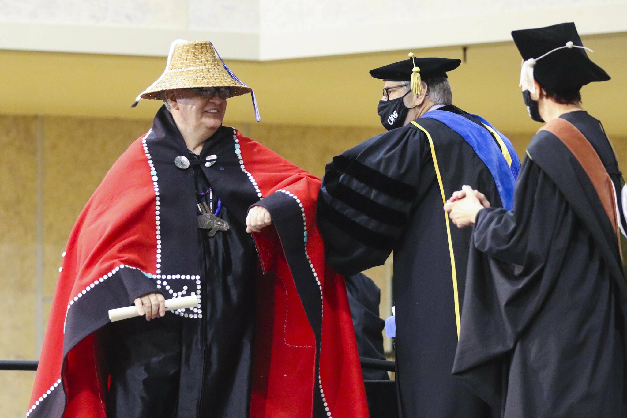 Robert Yates, left, receives his certificate for indigenous language teaching during the commencement ceremony for University of Alaska Southeast on May 1, 2022. (Michael S. Lockett / Juneau Empire)