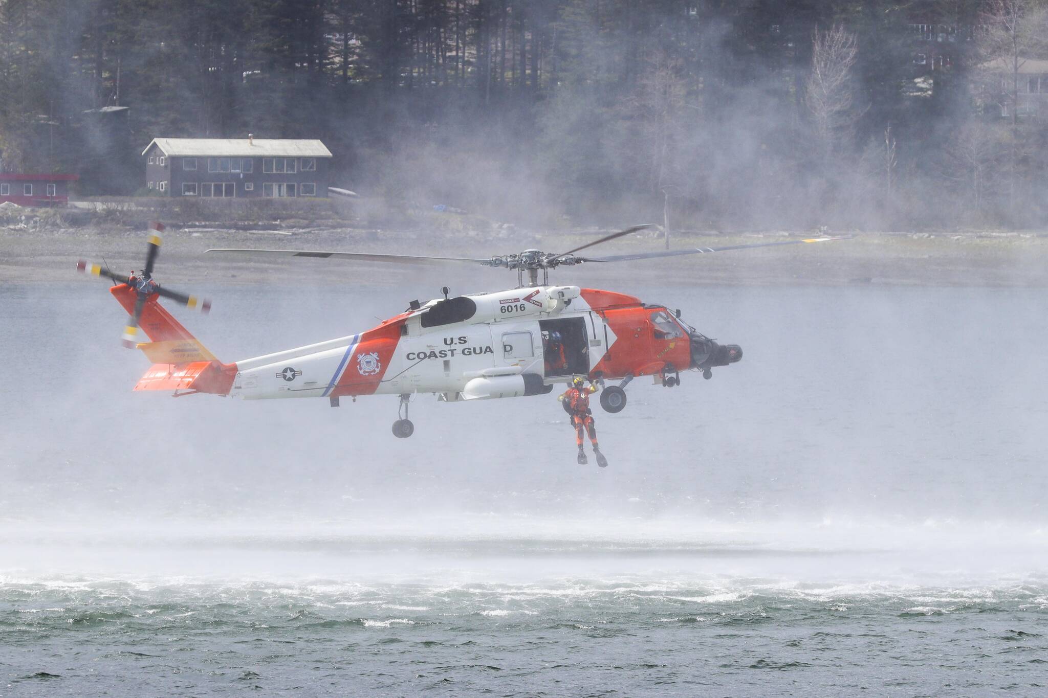 A rescue swimmer drops out of a Coast Guard Air Station Sitka MH-60 Jayhawk during a demonstration at the 12th Annual Maritime Festival on May 7, 2022. (Michael S. Lockett / Juneau Empire)