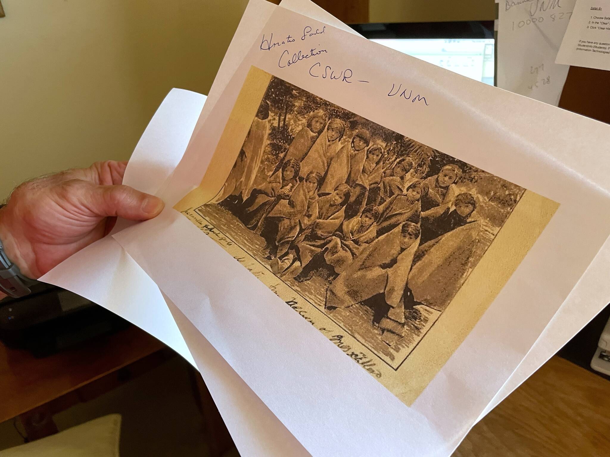 AP Photo / Susan Montoya Bryan
Adjunct history professor and research associate Larry Larrichio holds a copy of a late 19th century photograph of pupils at an Indigenous boarding school in Santa Fe during an interview July 8, 2021, in Albuquerque, New Mexico.