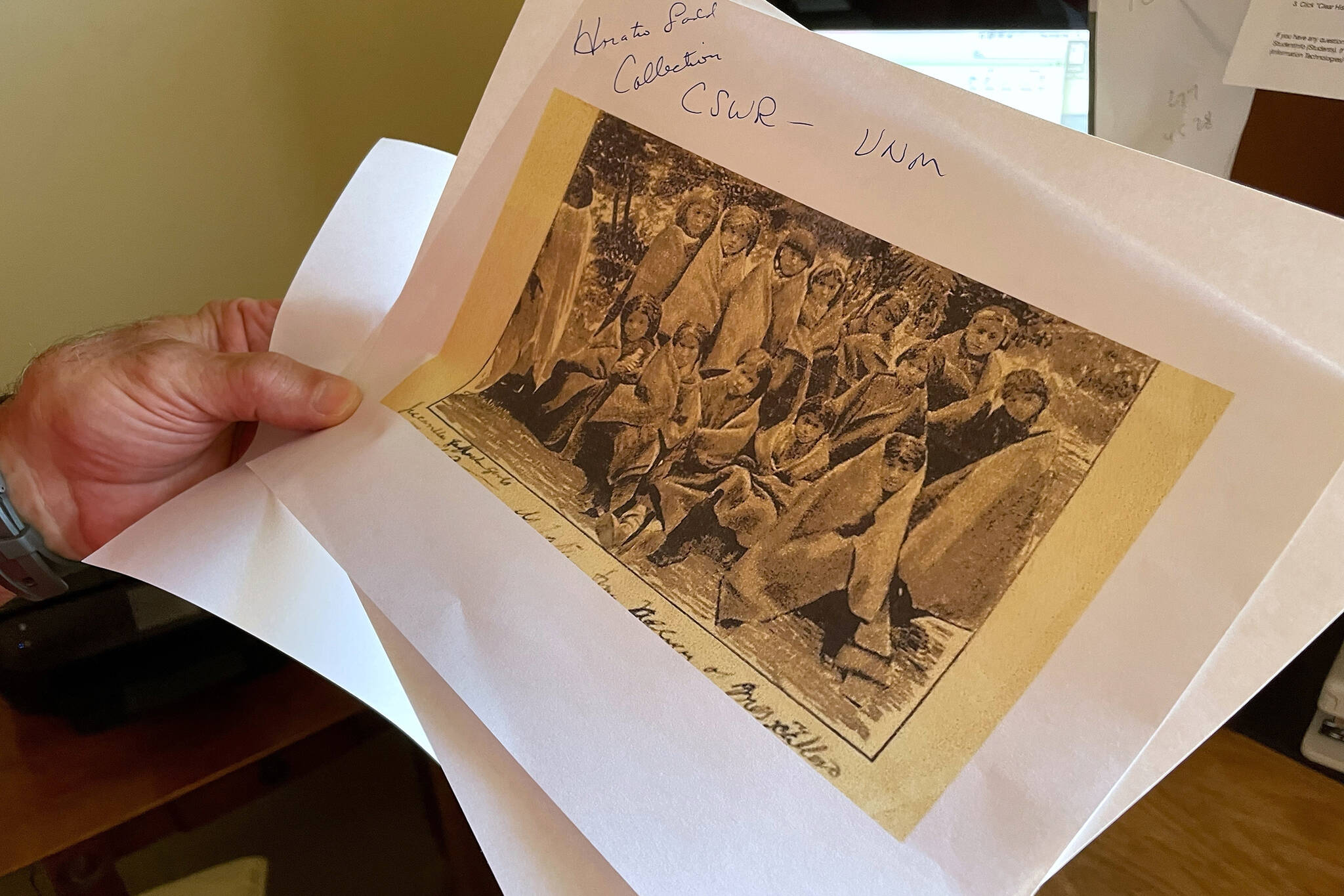 In this July 8, 2021, photo, adjunct history professor and research associate Larry Larrichio holds a copy of a late 19th century photograph of pupils at an Indigenous boarding school in Santa Fe during an interview in Albuquerque, New Mexico. The U.S. Interior Department is expected to release a report Wednesday, May 11, 2022, that it says will begin to uncover the truth about the federal government's past oversight of Native American boarding schools. (AP Photo/Susan Montoya Bryan, File)