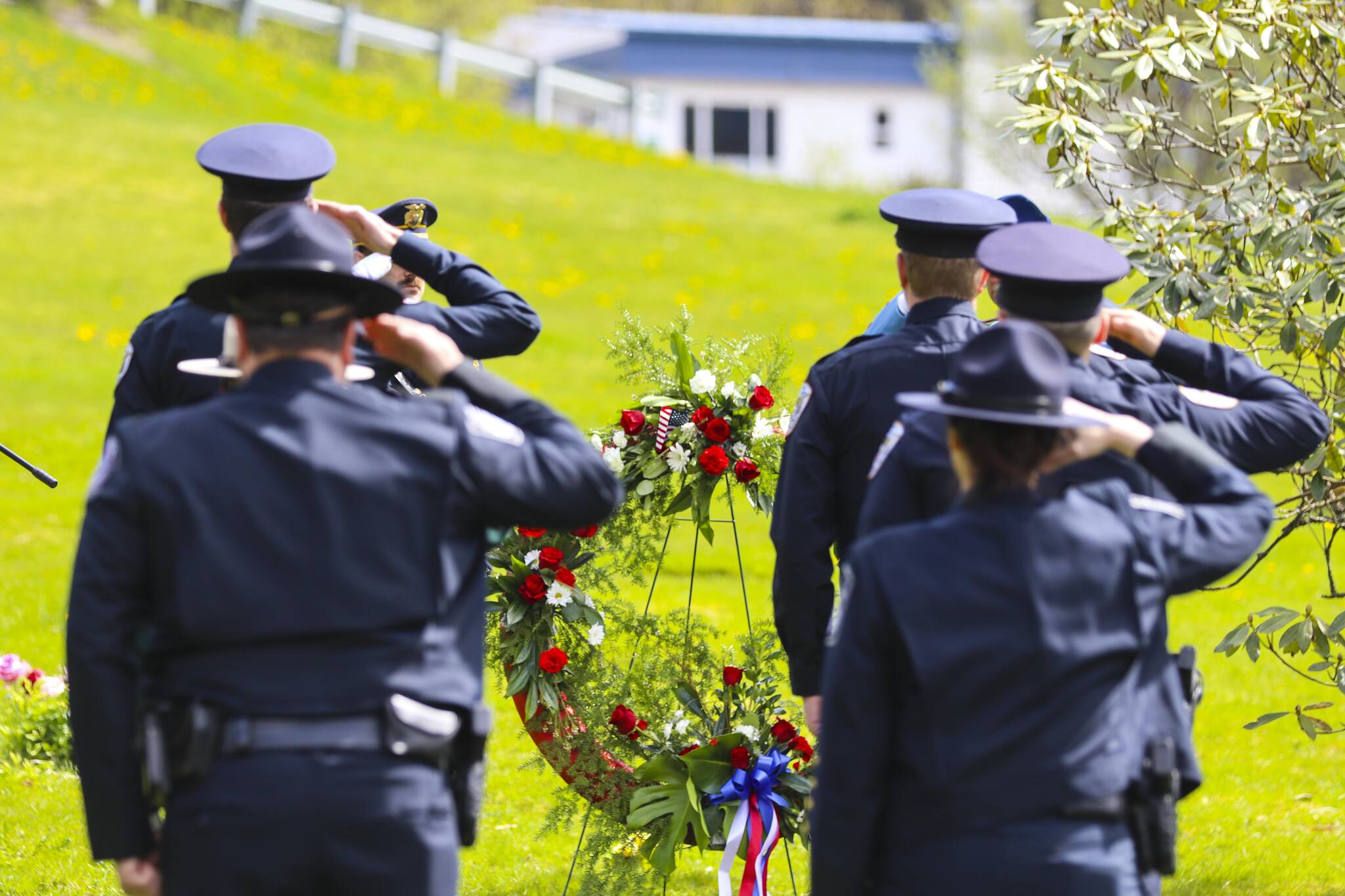 Michael S. Lockett / Juneau Empire
Law enforcement personnel salute as officers lay a ceremonial wreath on the grave of a dead officer at Evergreen Cemetery for Peace Officers Memorial Day on May 13, 2022.