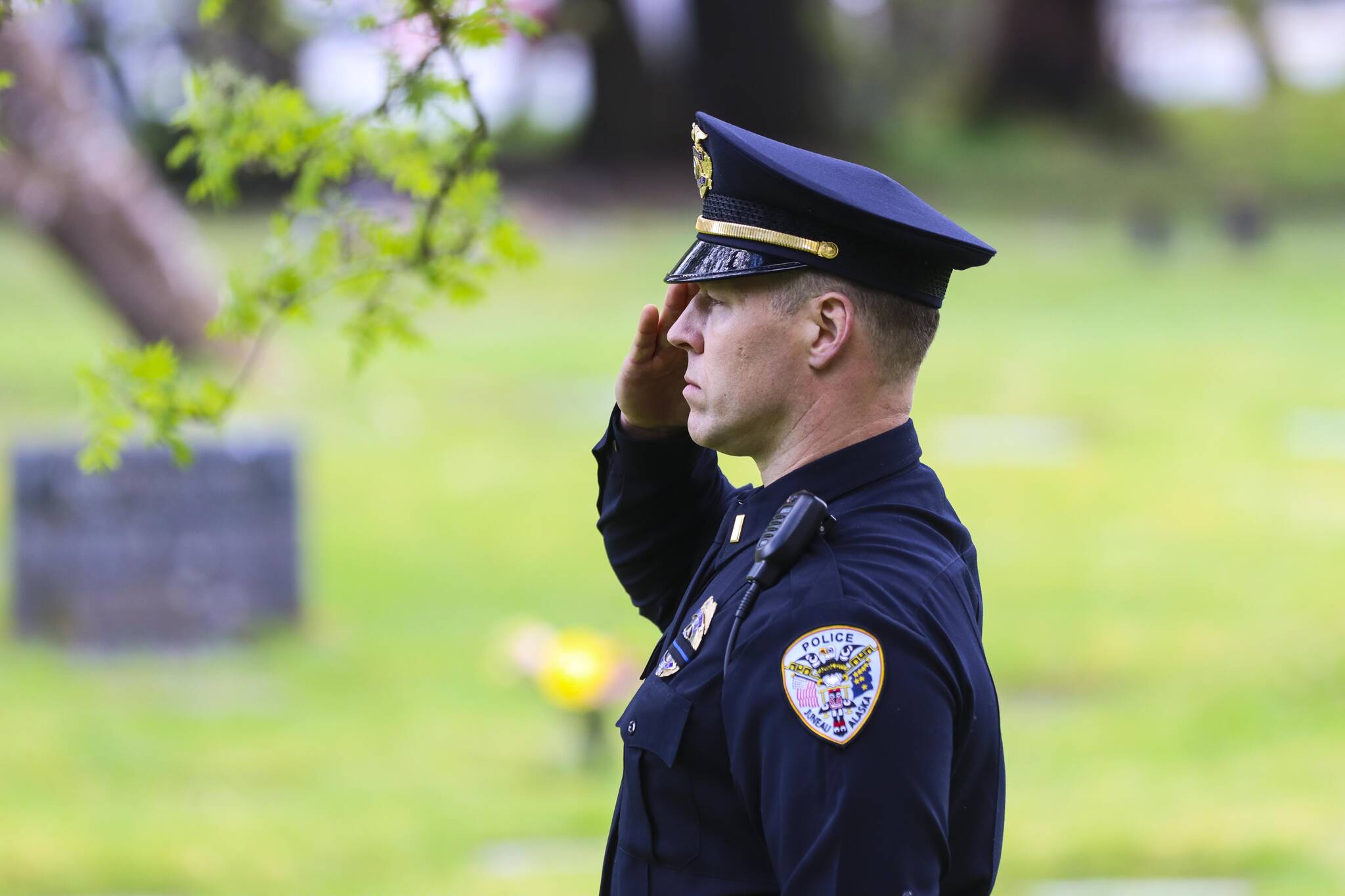 Michael S. Lockett / Juneau Empire
Lt. Krag Campbell of the Juneau Police Department salutes as officers lay a wreath on the grave of an officer who was killed on duty during a Peace Officers Memorial Day ceremony at Evergreen Cemetery on May 13, 2022.