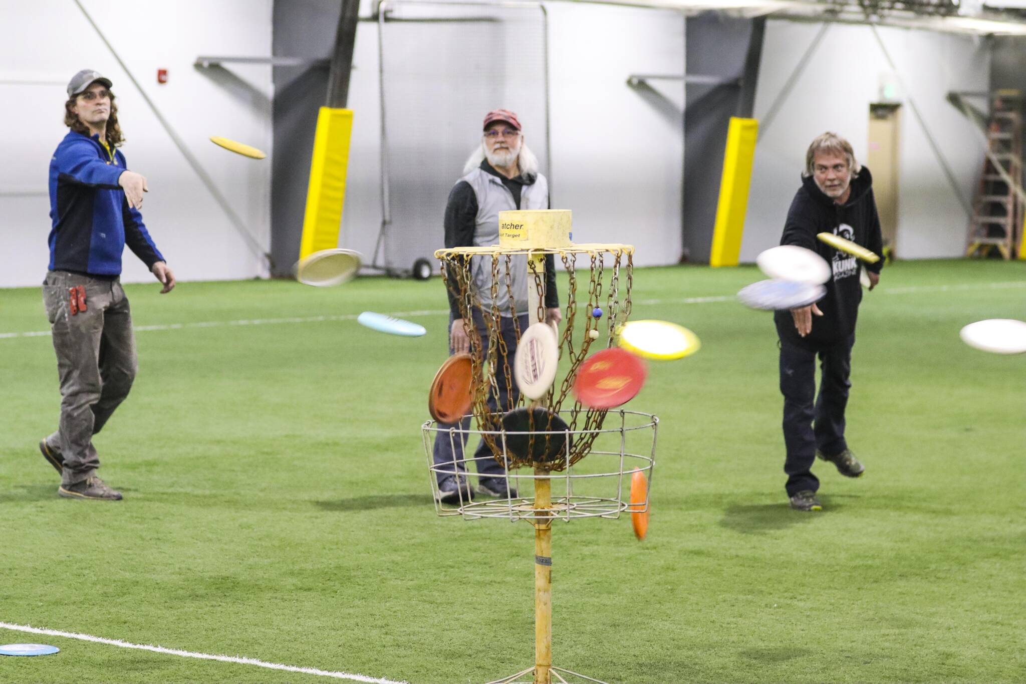 Michael S. Lockett / Juneau Empire
Players at a disc golf community workshop held by Uplay throw discs at the target at Dimond Park Field House on May 12, 2022.