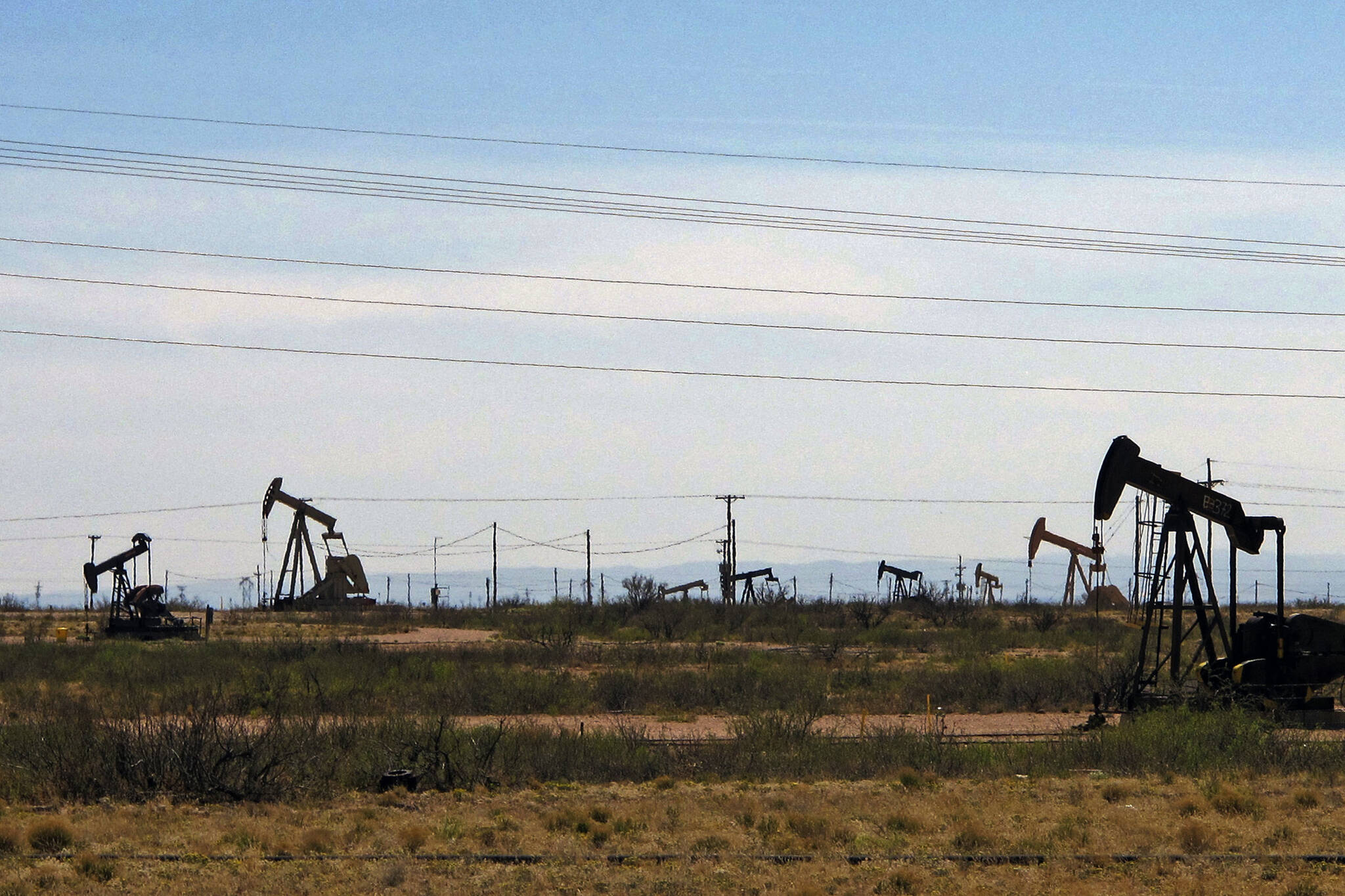 Oil rigs stand in the Loco Hills field along U.S. Highway 82 in Eddy County, near Artesia, N.M., one of the most active regions of the Permian Basin. Government budgets are booming in New Mexico. The reason behind the spending spree — oil. New Mexico is the No. 2 crude oil producer among U.S. states and the top recipient of U.S. disbursements for fossil fuel production on federal land. But a budget flush with petroleum cash has a side effect: It also puts the spotlight on how difficult it is for New Mexico and other states to turn their rhetoric on tackling climate change into reality. (AP Photo / Jeri Clausing)