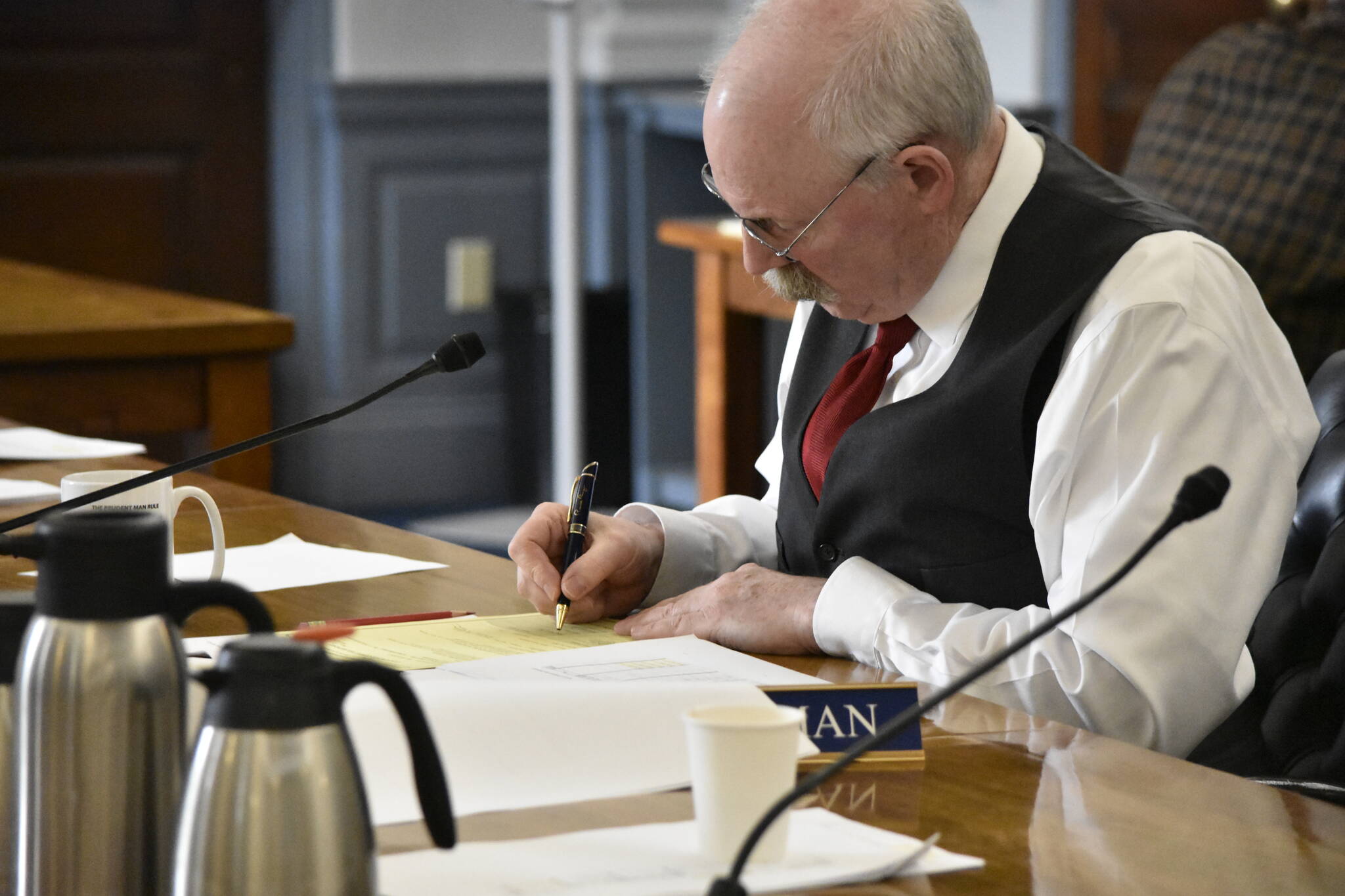 Sen. Bert Stedman, R-Sitka, chair of the bicameral conference committee tasked with hammering out differences in the state’s budget bill, signs the committee report as members finished their work on Tuesday, May 17, 2022. (Peter Segall / Juneau Empire