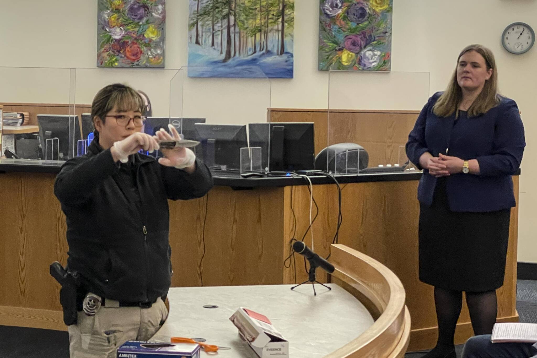Detective Kathy Underwood of the Juneau Police Department shows the jury the weapon used to stab the victim in a 2019 attack to death during the trial on May 19, 2022. (Michael S. Lockett / Juneau Empire)