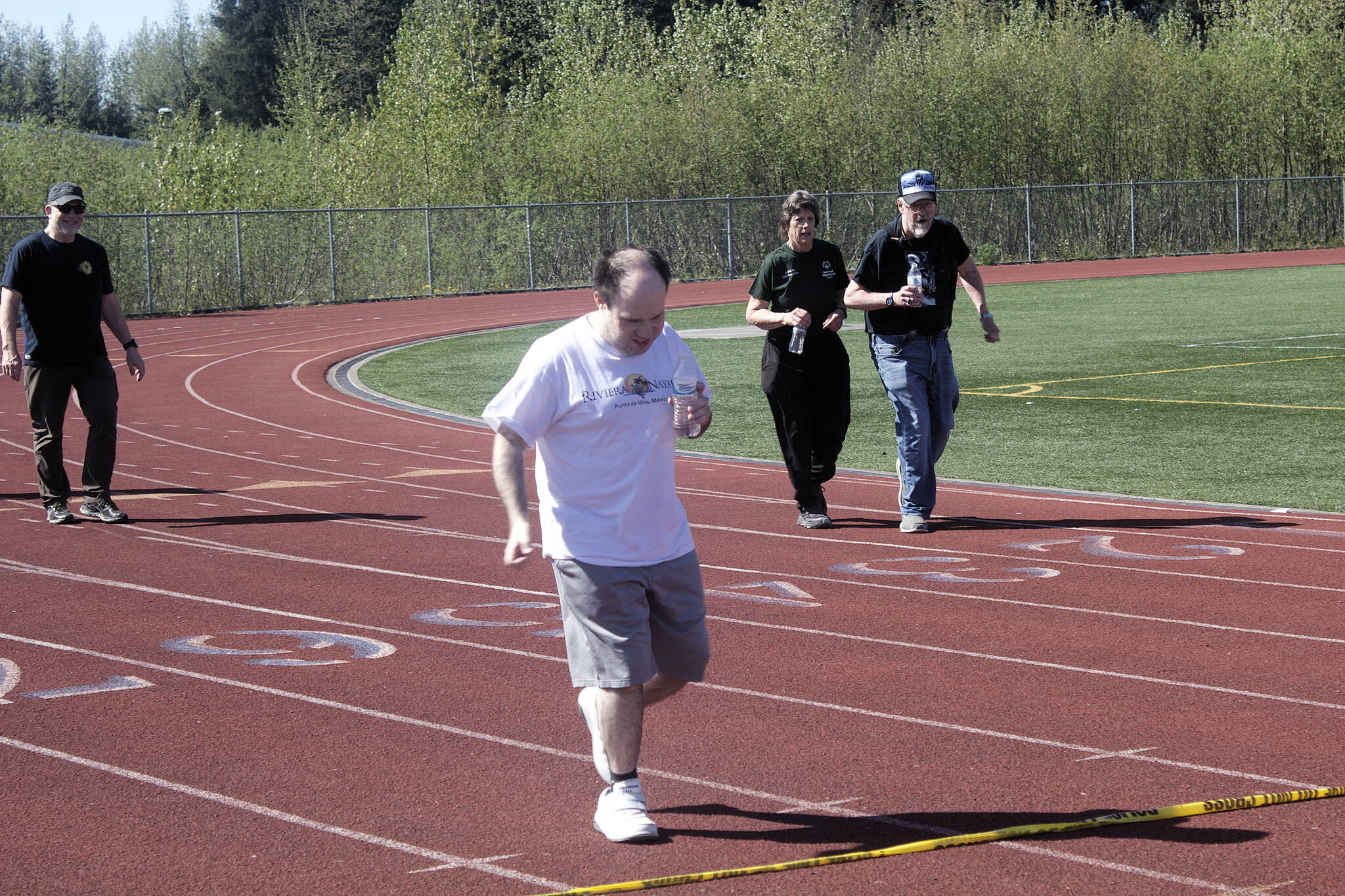 Andreas Jones crosses the finish line during the annual Alaska Law Enforcement Torch Run at Thunder Mountain High School on Saturday morning. Nine disabled athletes and about 20 others participated in the race in Juneau, one of 15 communities statewide raising money for Special Olympics Alaska as part of the event. (Mark Sabbatini / Juneau Empire)