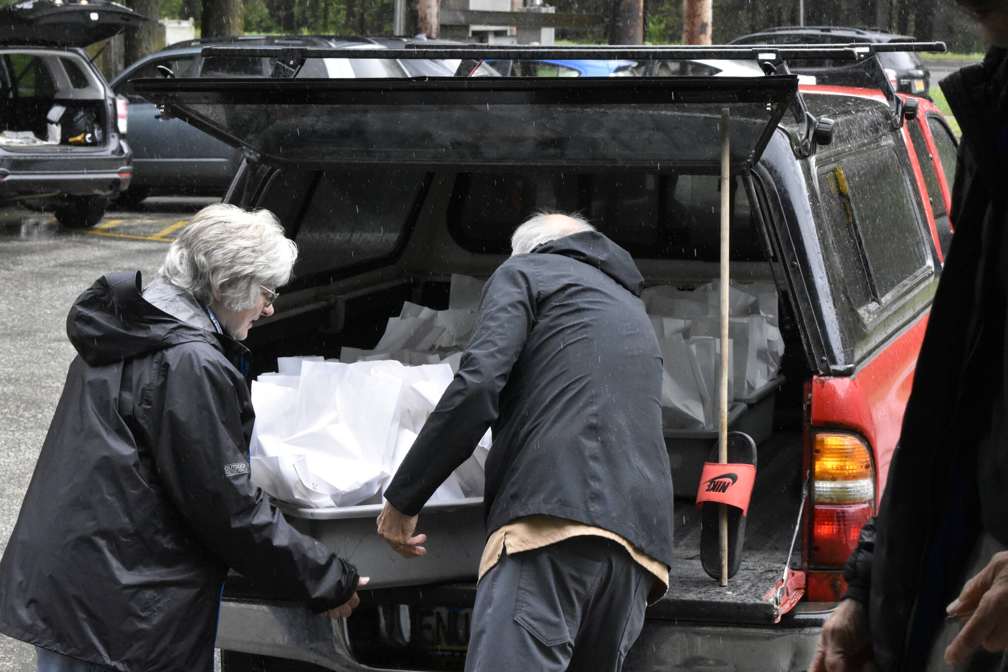 Helen Unruh and John Haywood unload prepared meals St. Paul’s Catholic Church for the Meals on Wheels program on Monday, May 23, 2022. (Peter Segall / Juneau Empire)
