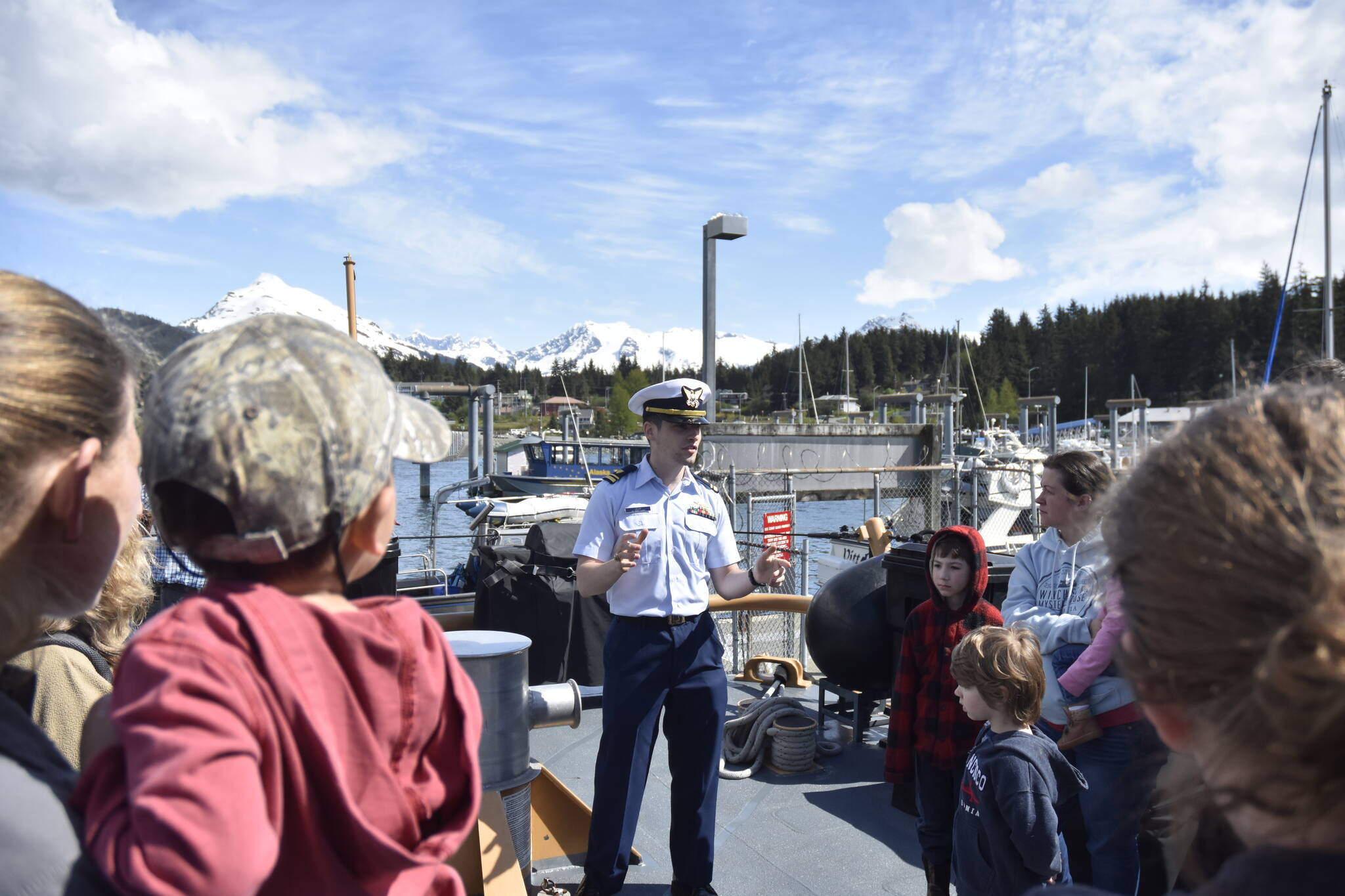 On the deck of the U.S. Coast Guard cutter Liberty, Lt. j.g. Quinn Levy gives visitors a history of the vessel to guests on Thursday, May 26, 2022. The Liberty has been stationed in Juneau for more than 30 years but is being re-homeported in Valdez. (Peter Segall / Juneau Empire)