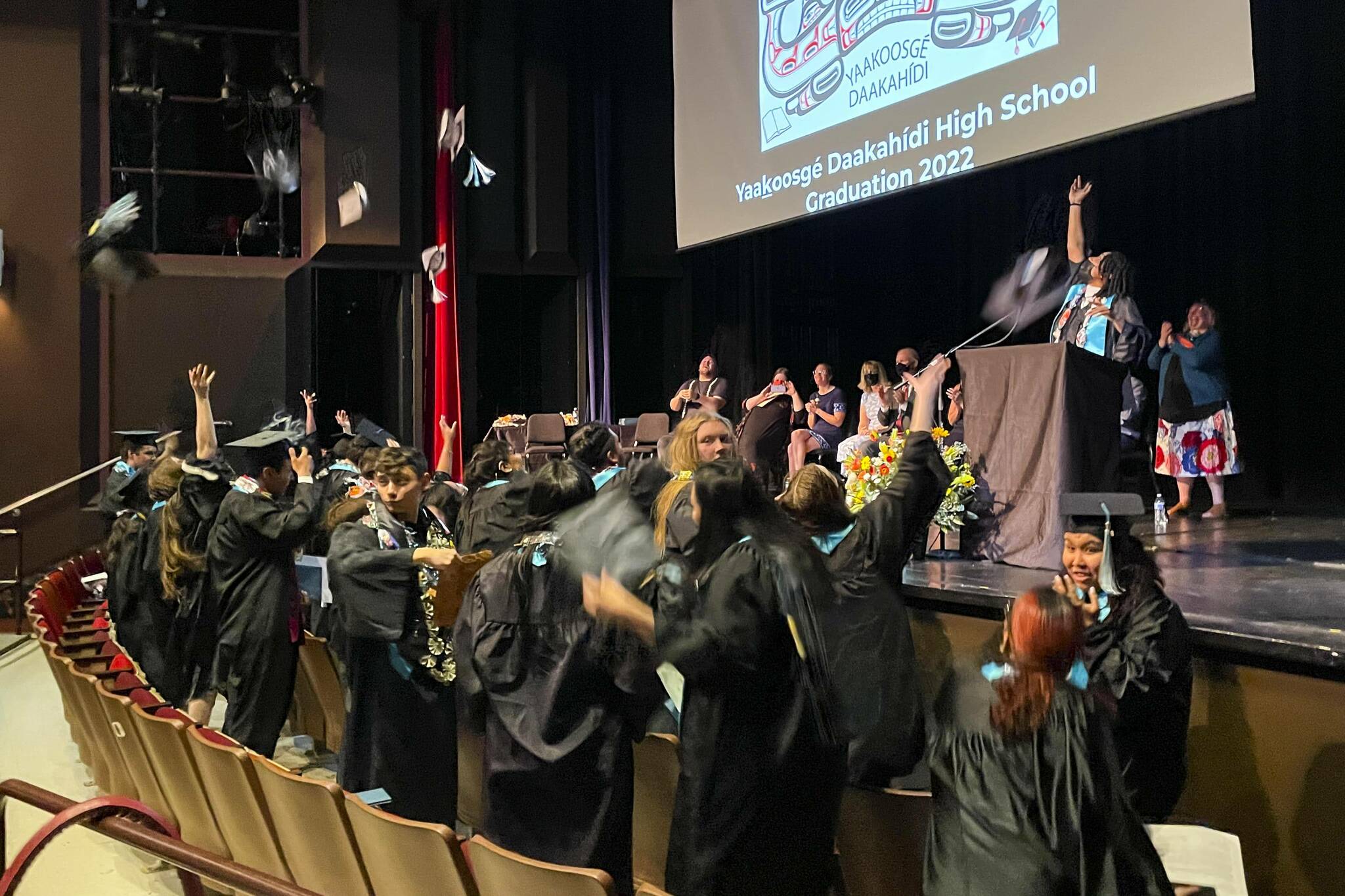 Yaakoosgé Daakahídi High School graduates toss their caps at the conclusion of the graduation ceremony on May 29, 2022. (Michael S. Lockett / Juneau Empire)