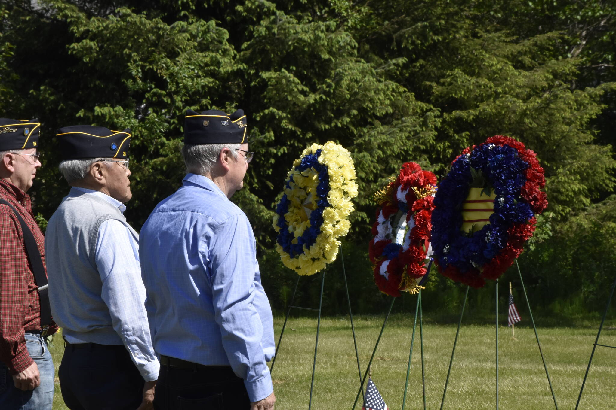 From left to right, William Clutton, Ed Grant, and Bill Morris, lay wreaths at a Memorial Day ceremony at the Alaska Memorial Park in the Mendenhall Valley on Monday, May 30, 2022. (Peter Segall / Juneau Empire)