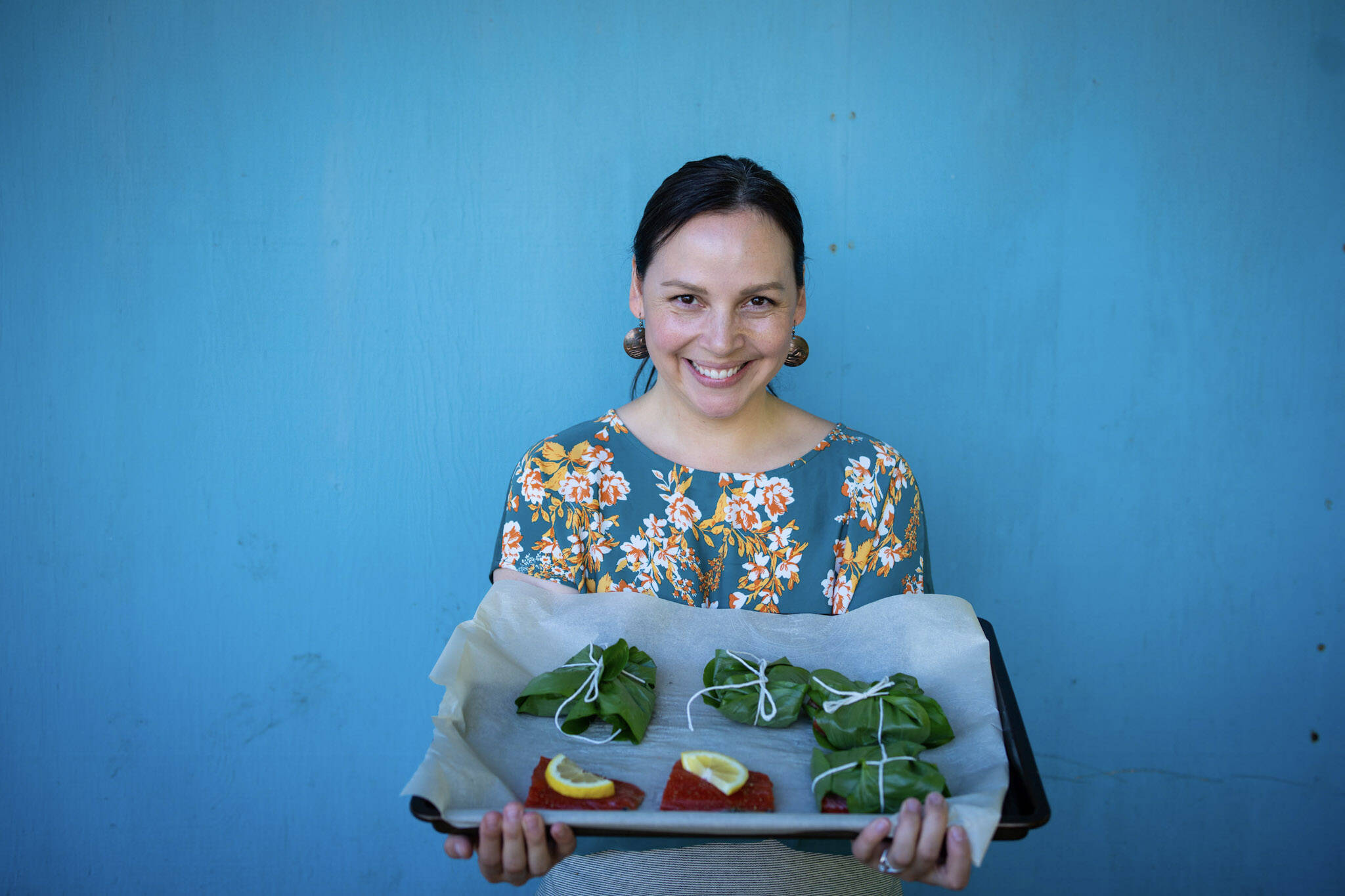 Mary Goddard holds salmon filets wrapped in deer heart leaves. (Courtesy Photo / Bethany Sonsini Goodrich)