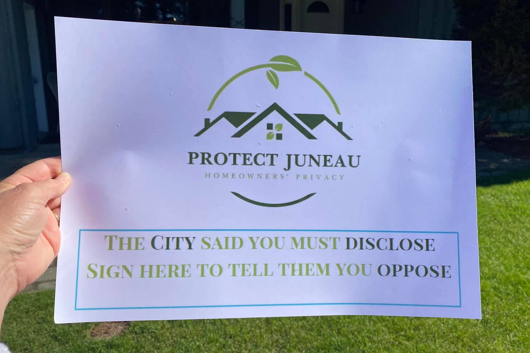 A sign asking Juneau residents to sign a petition eliminating a requirement that property buyers disclose their purchase price is displayed by a signature gatherer during a collection effort earlier this month. The petition appears to have gathered enough signatures to appear on municipal ballots in October. (Courtesy Photo / Southeast Alaska Board of Realtors)