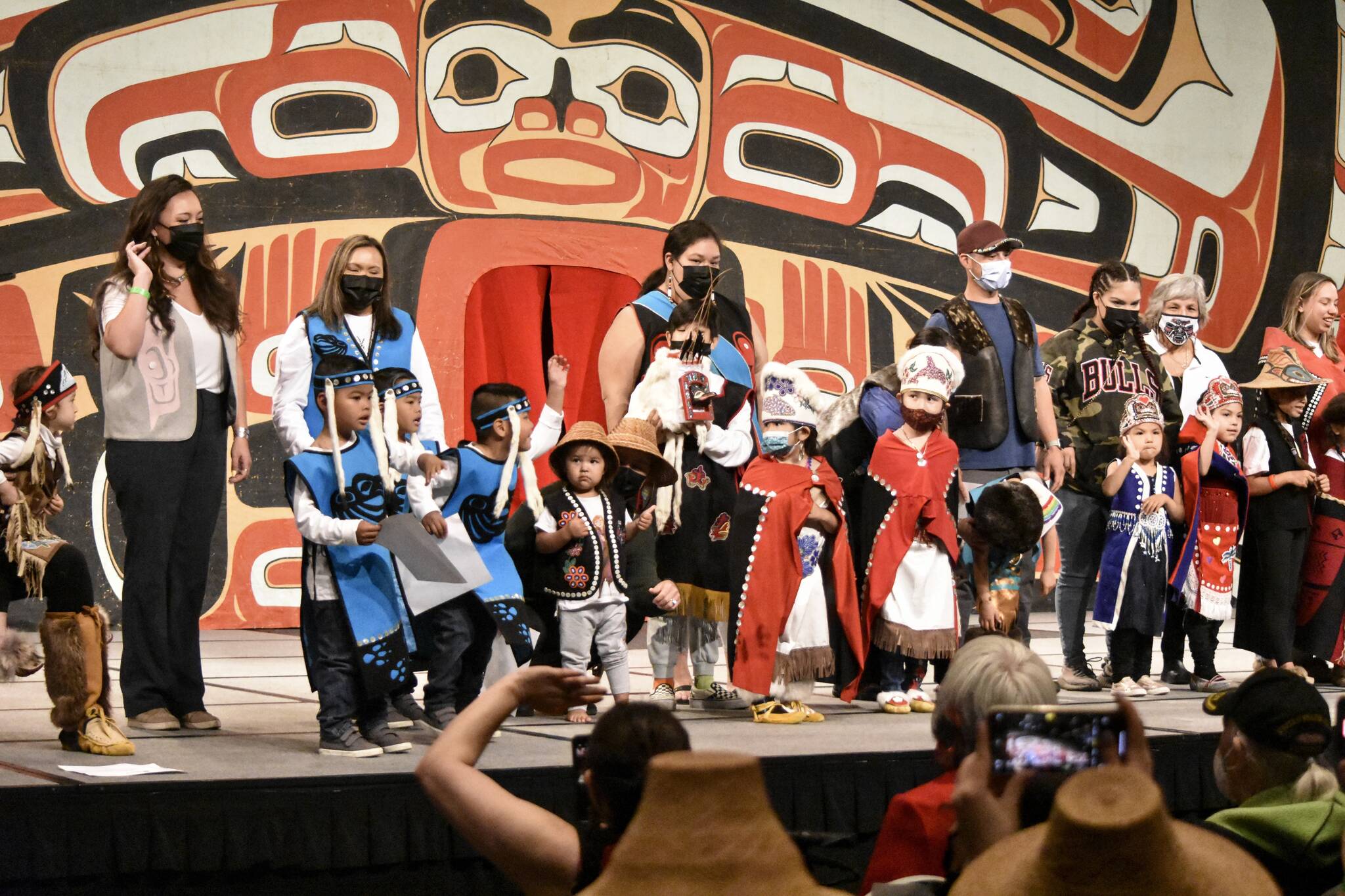 Performers and their families wave to the crowd at the end of the Toddler Regalia Review at Centennial Hall on Friday, June 10, 2022, part of Celebration 2022. Performers were aged 2-5, and wore regalia made for them by friends and family. (Peter Segall / Juneau Empire)