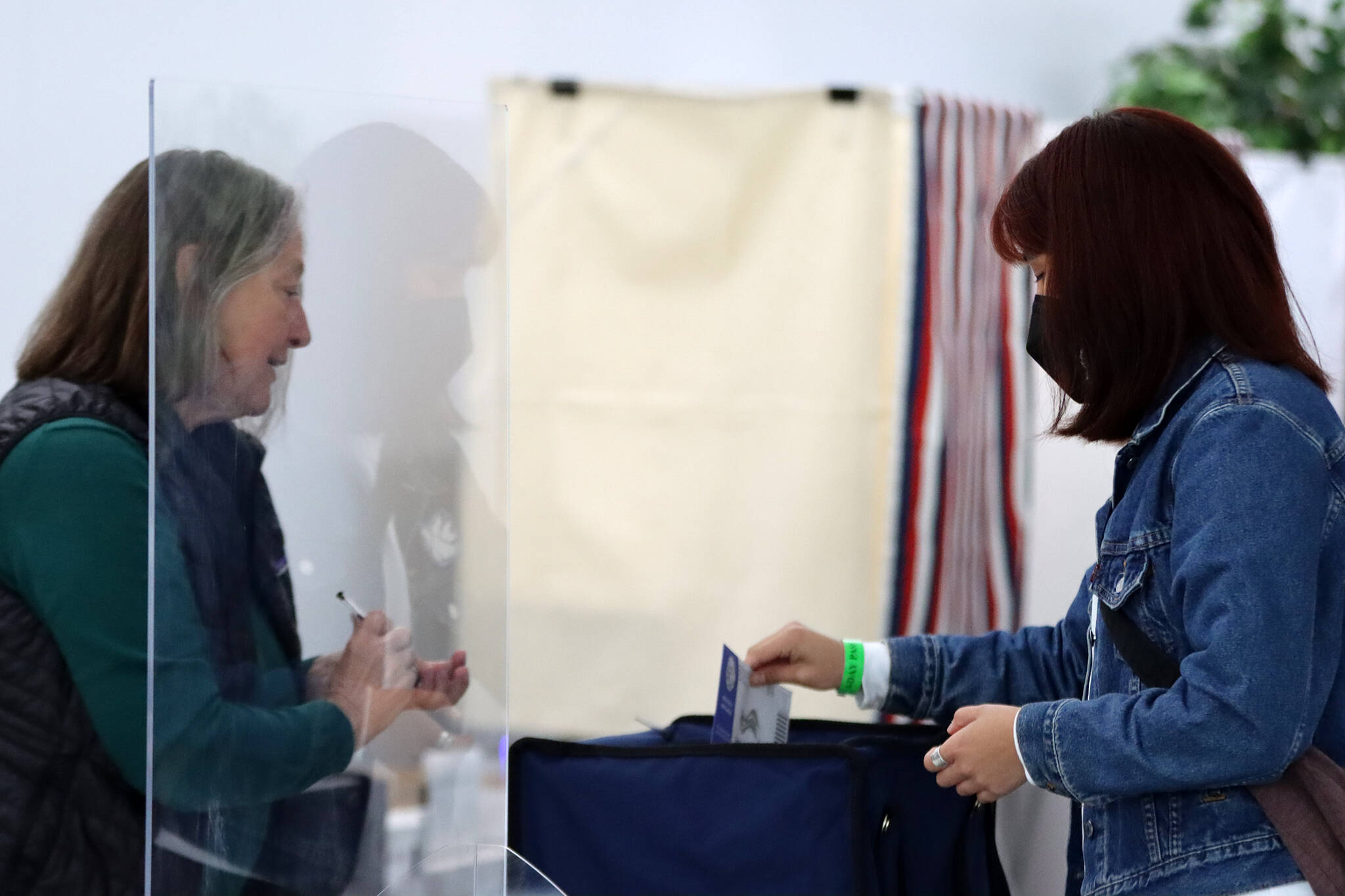 Election official Barb Murray watches as voter Alicia Duncan places her ballot in a receptacle during the special primary election to fill Alaska’s lone seat in the U.S. House of Representatives. (Ben Hohenstatt / Juneau Empire)
