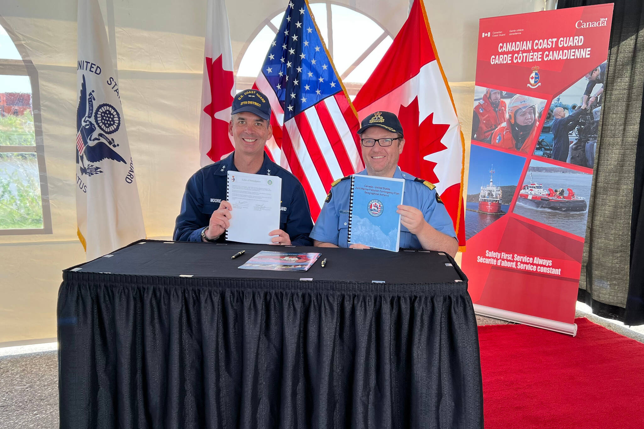 Rear Adm. Nathan Moore, U.S. Coast Guard 17th District, commander, left, and Neil O’Rourke, Canadian Coast Guard Arctic Region, assistant commissioner, holding the officially signed Beaufort Sea Annex, at Hay River Base, Northwest Territories, Canada, June 8, 2022. (PO2 Alexandria Preston / USCG)