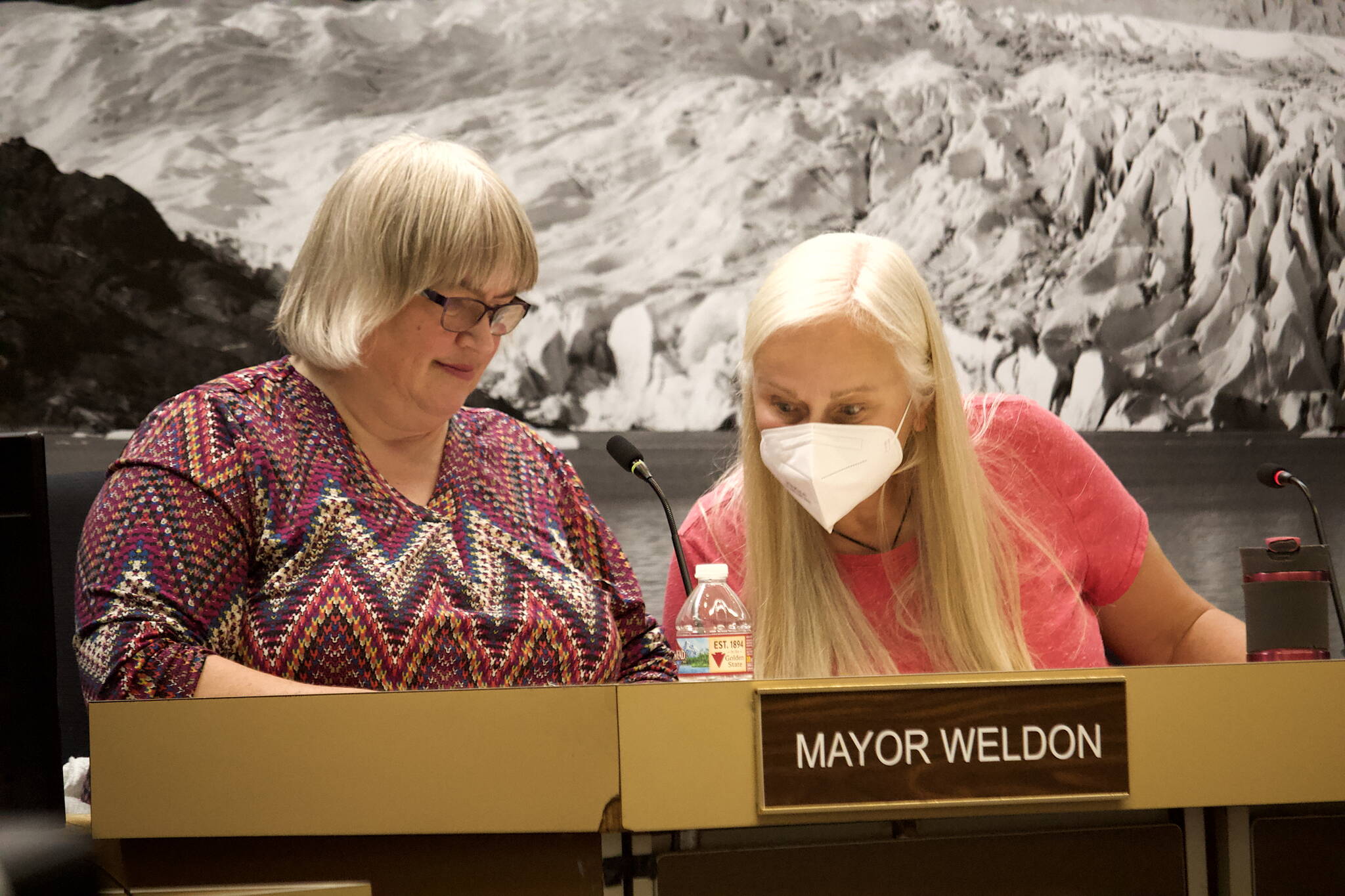 Juneau Mayor Beth Weldon, left, and Deputy Mayor Maria Gladziszewski review a portion of the city’s spending plan for the upcoming year before the Juneau Assembly unanimously approved it Monday night. (Mark Sabbatini / Juneau Empire)