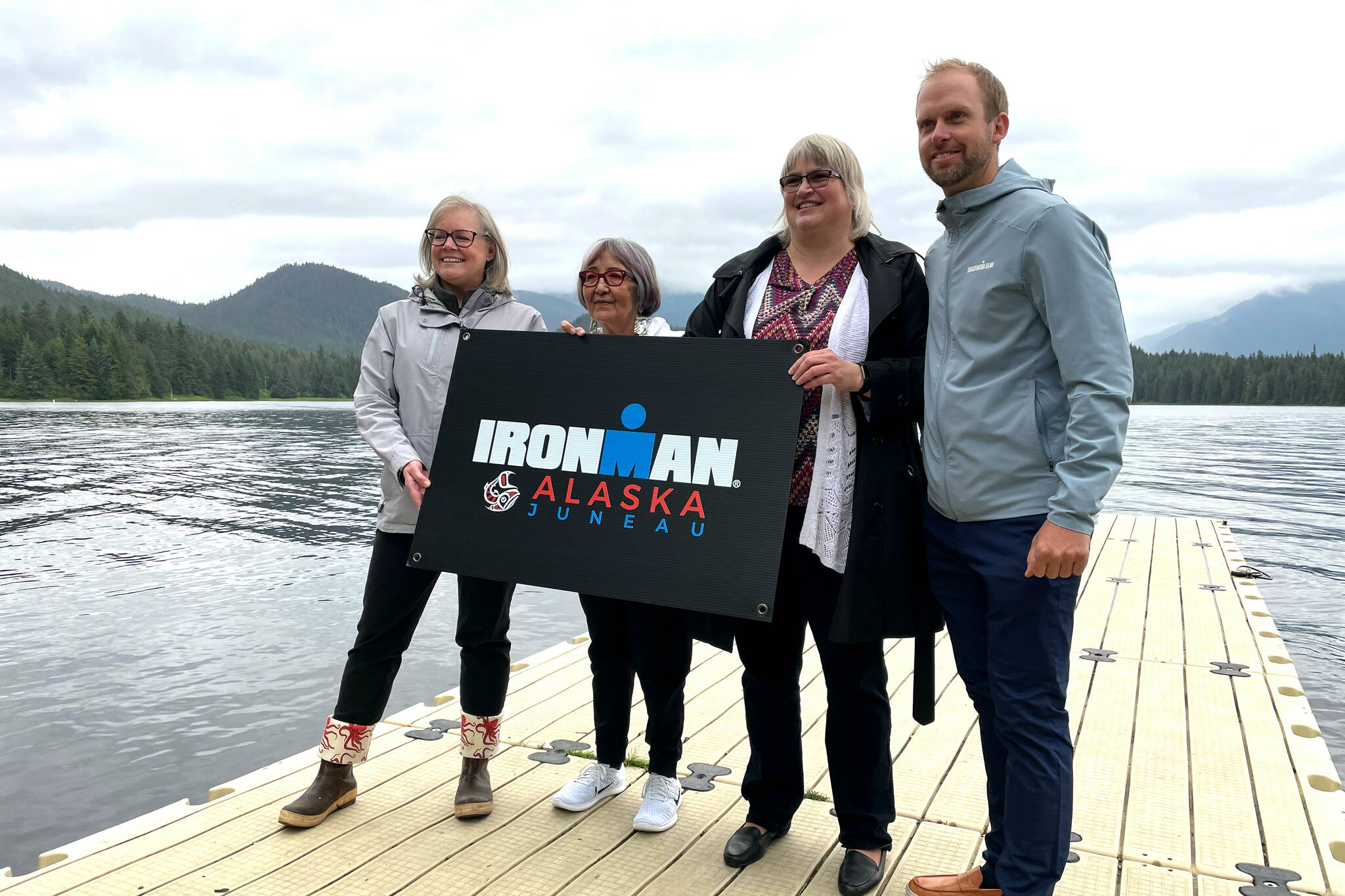 Travel Juneau CEO and President Liz Perry, Sealaska Heritage Institute President Rosita Worl, City and Borough of Juneau Mayor Beth Weldon, and Ironman regional director Dave Christen hold a sign for the 2022 Juneau Ironman event as they announce the race’s Alaska debut on the University of Alaska- Southeast campus on Aug. 9, 2021. (Michael S. Lockett / Juneau Empire File)