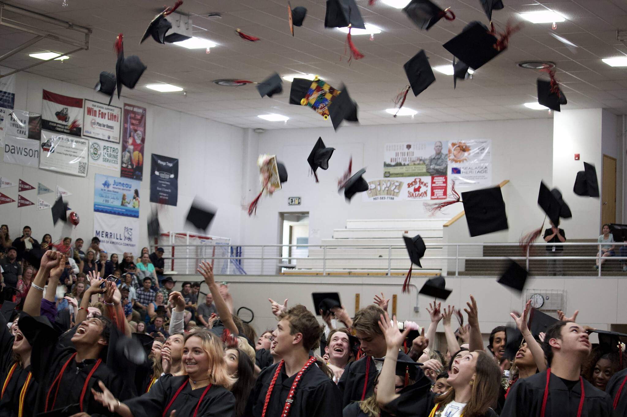 Juneau-Douglas High School: Yadaa.at Kalé graduates toss their caps during graduation last month. The Juneau School District Board of Education approved on Friday a policy formally allowing students to wear cultural regalia during graduation and other significant ceremonies and events. (Mark Sabbatini / Juneau Empire)
