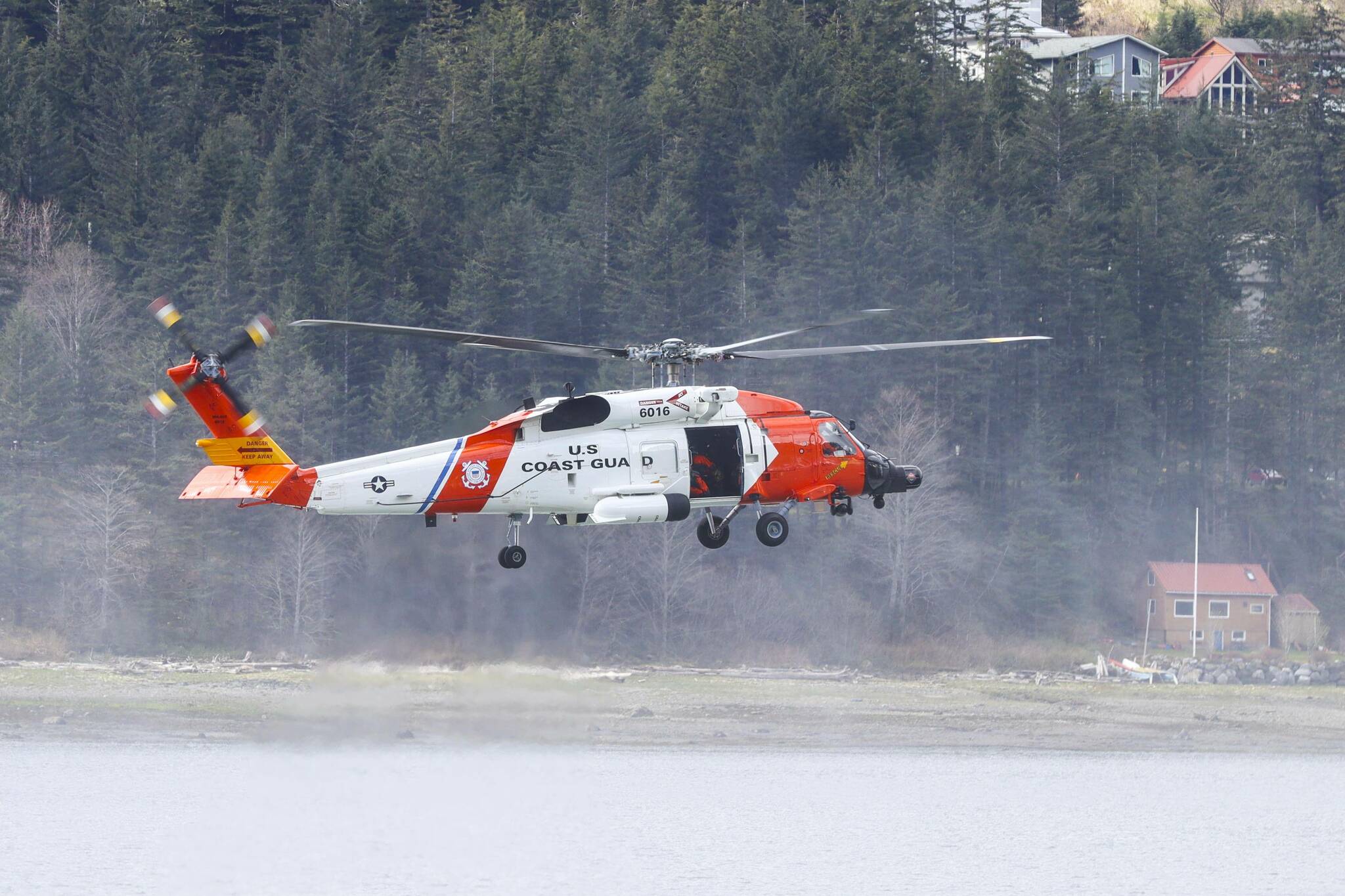 A Coast Guard MH-60 Jayhawk hovers over Juneau harbor. A similar aircraft was involved in a medevac from a vessel at sea of a passenger with a medical condition on June 21, 2022. (Michael S. Lockett / Juneau Empire File)