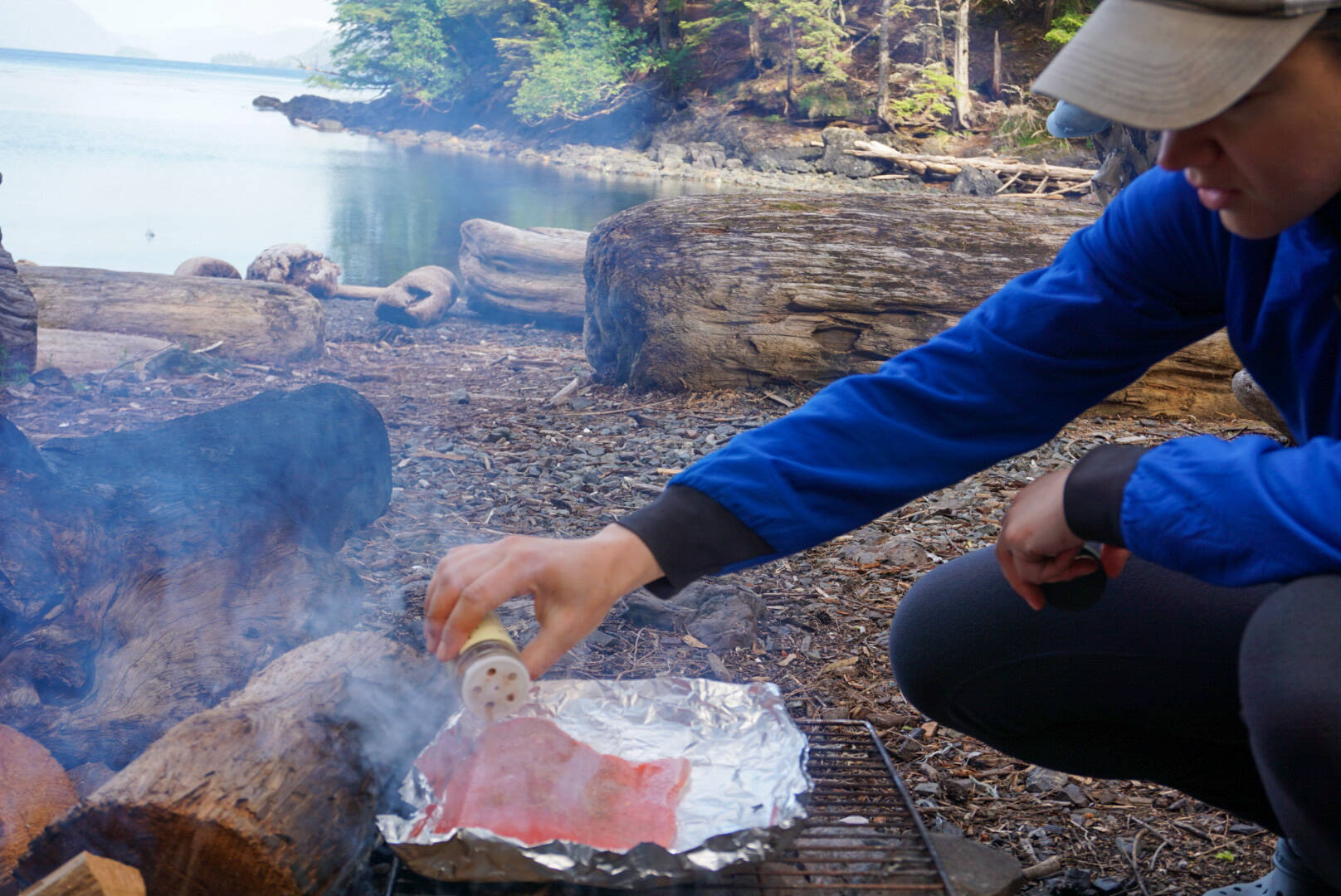 The author’s wife seasons a fresh chunk of king salmon for dinner at the Point Amargura forest service cabin near Craig. (Jeff Lund / For the Juneau Empire)