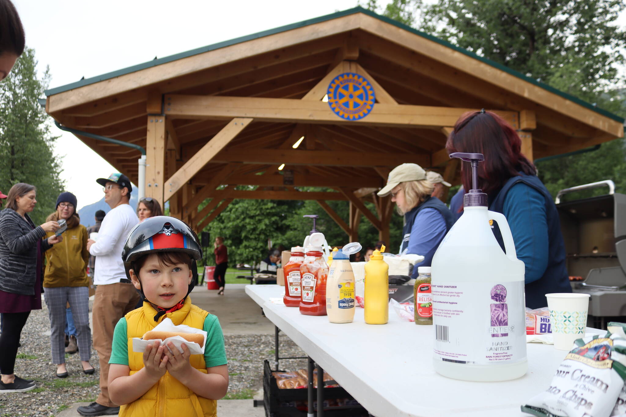 Kobe Rielly grabs a hot dog Wednesday evening at the grand unveiling of the new pavilion at Riverside Rotary Park. (Clarise Larson / Juneau Empire)