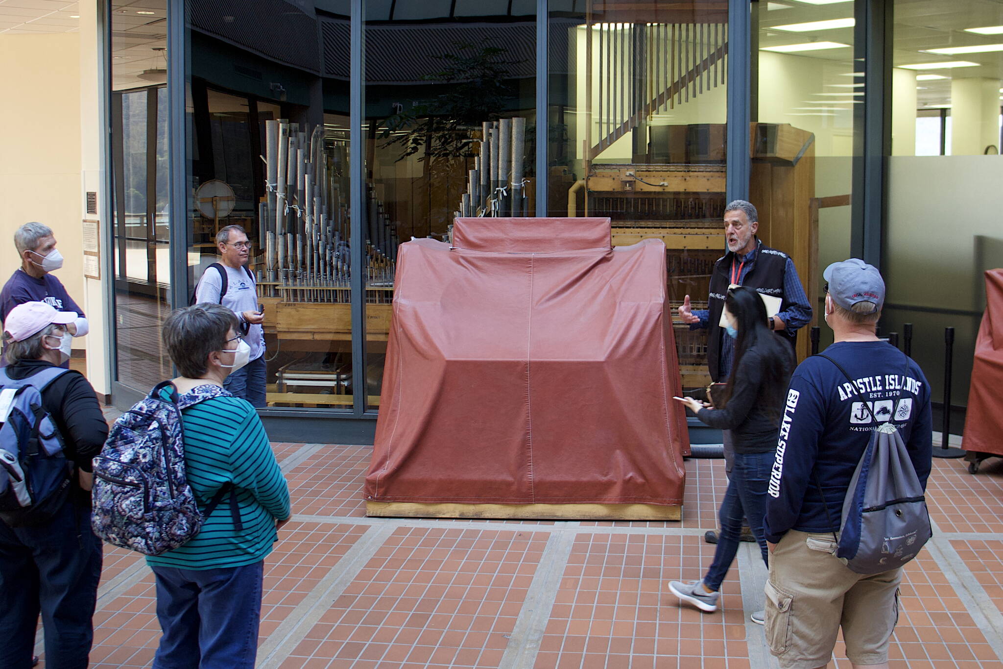 Peter Froehlich, a retired Juneau district judge who is now a volunteer tour guide, explains the history of the history of the Kimball Theatre Pipe Organ in the State Office Building to a group of visitors Thursday. The organ has been idle since 2020 due to the COVID-19 pandemic, and now needs repairs before regular Friday lunchtime concerts and other performances on the 94-year-old instrument can resume. (Mark Sabbatini / Juneau Empire)