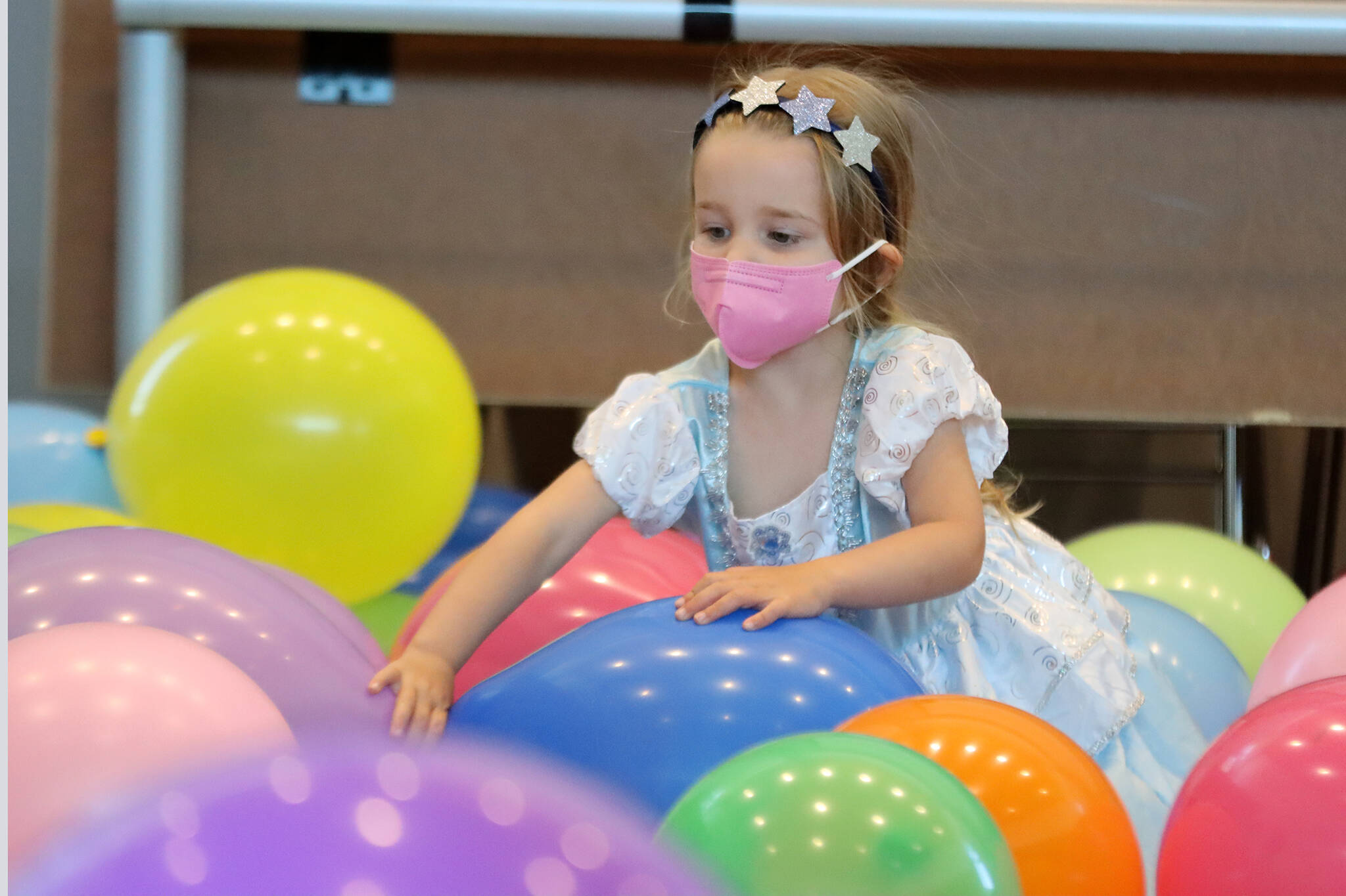Ava Sell, 3, enjoys balloons left over from a Juneau Dental Society event before Drag Storytime at the Mendenhall Valley Public Library. (Ben Hohenstatt / Juneau Empire)