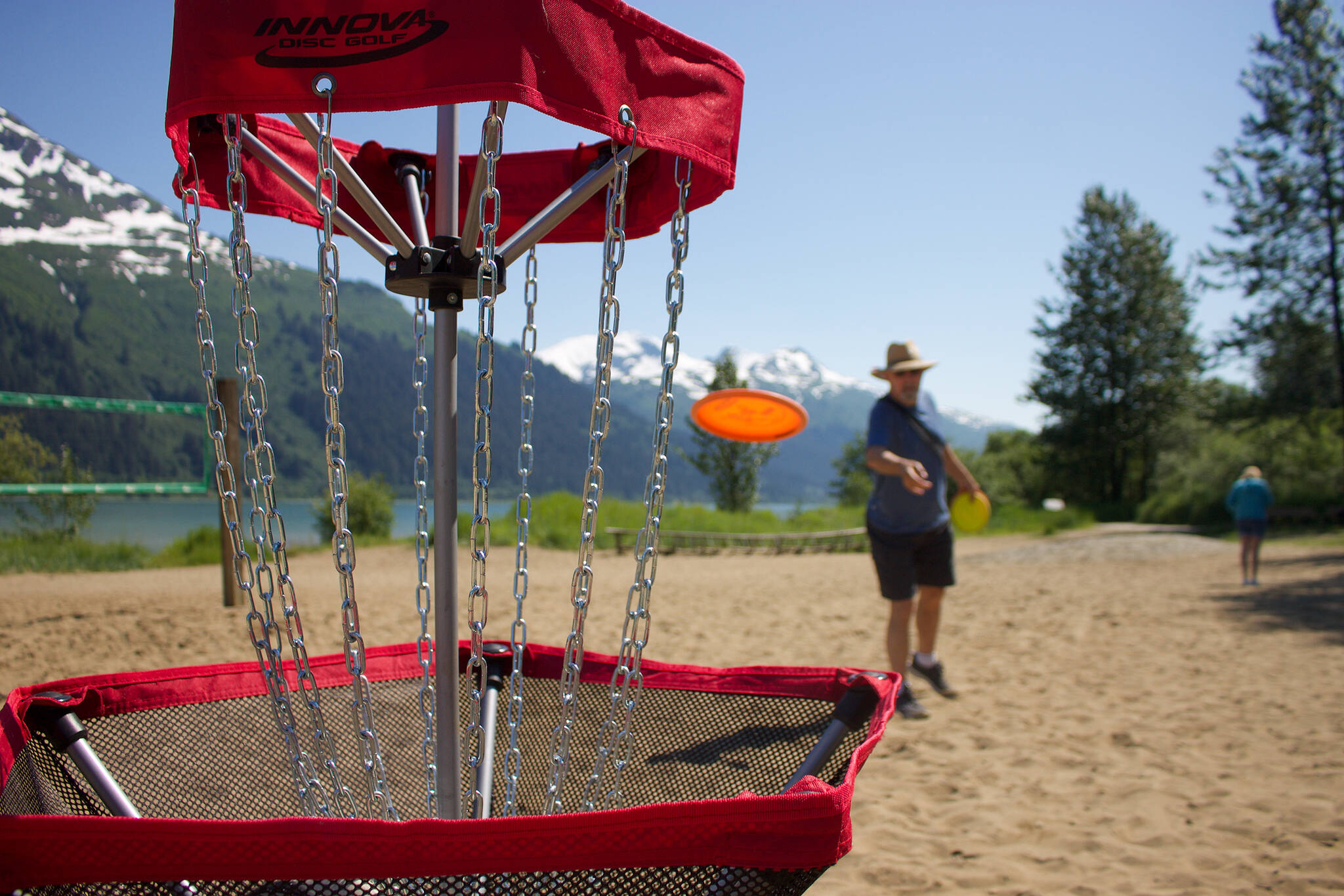 Pioneers of Alaska member Ricky Deising lands a hole-in-one as he tries frisbee golf for the first time on Sandy Beach, Douglas.(Clarise Larson / Juneau Empire)