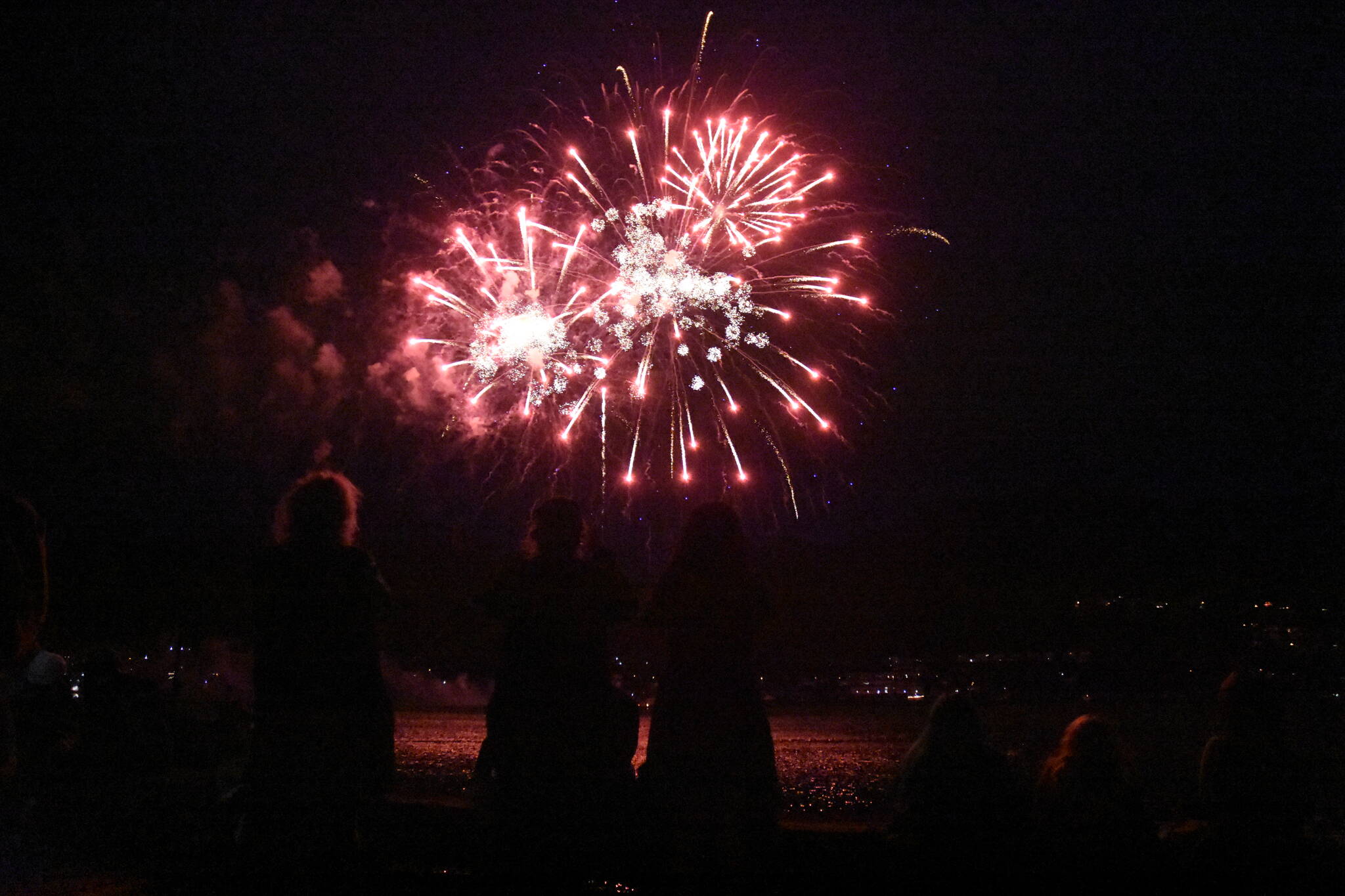 Rockets’ red glare illuminates the night sky and spectators during the City and Borough of Juneau’s fireworks display on July 3, 2021. (Peter Segall / Juneau Empire File)