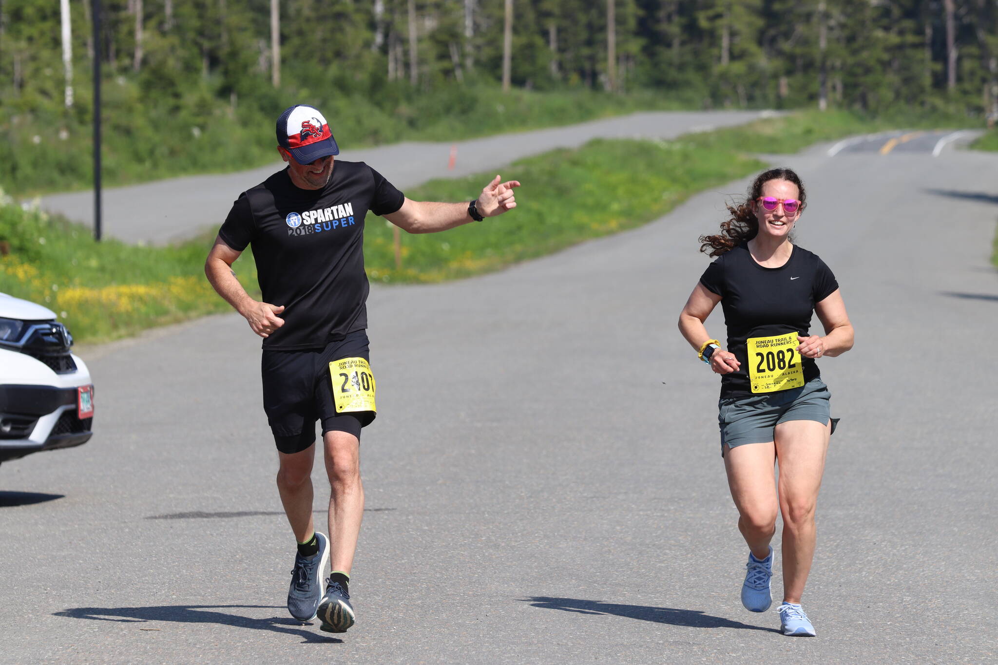 Addison Field, left, cheers for Geneva Peters as she sprints in to the finish during the Eaglecrest Road and Ridge Race on July 2, 2022. (Michael S. Lockett / Juneau Empire)