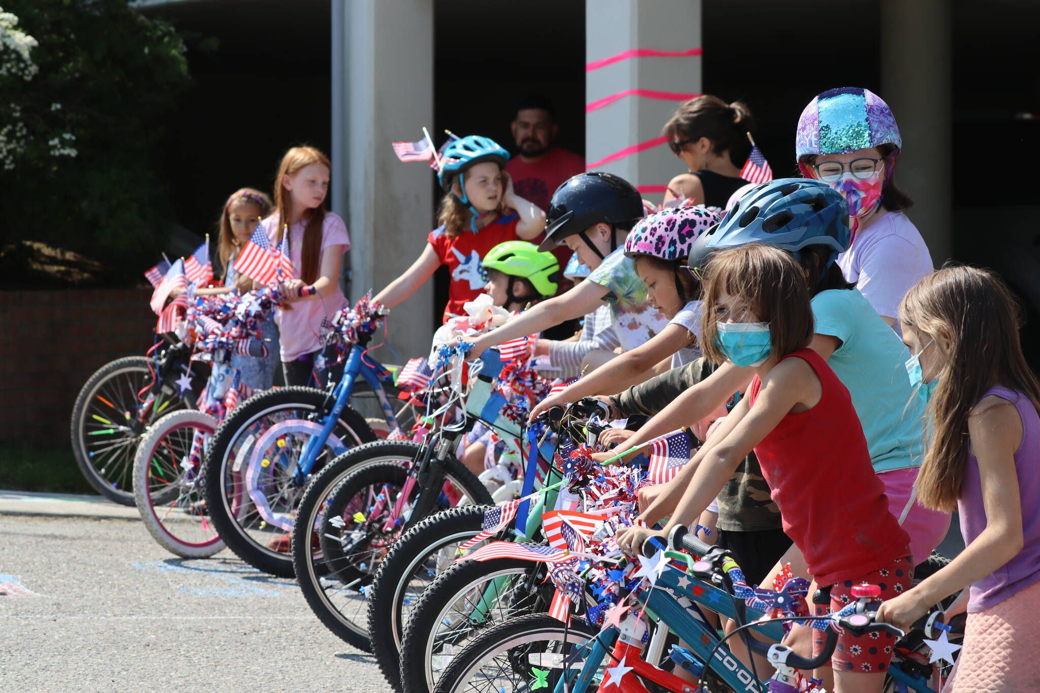 Douglas kids line up with their freshly decorated rides during the Douglas Fourth of July Committee’s annual Bicycle Decorating session held at the Douglas Public Library on July 2, 2022. (Michael S. Lockett / Juneau Empire)